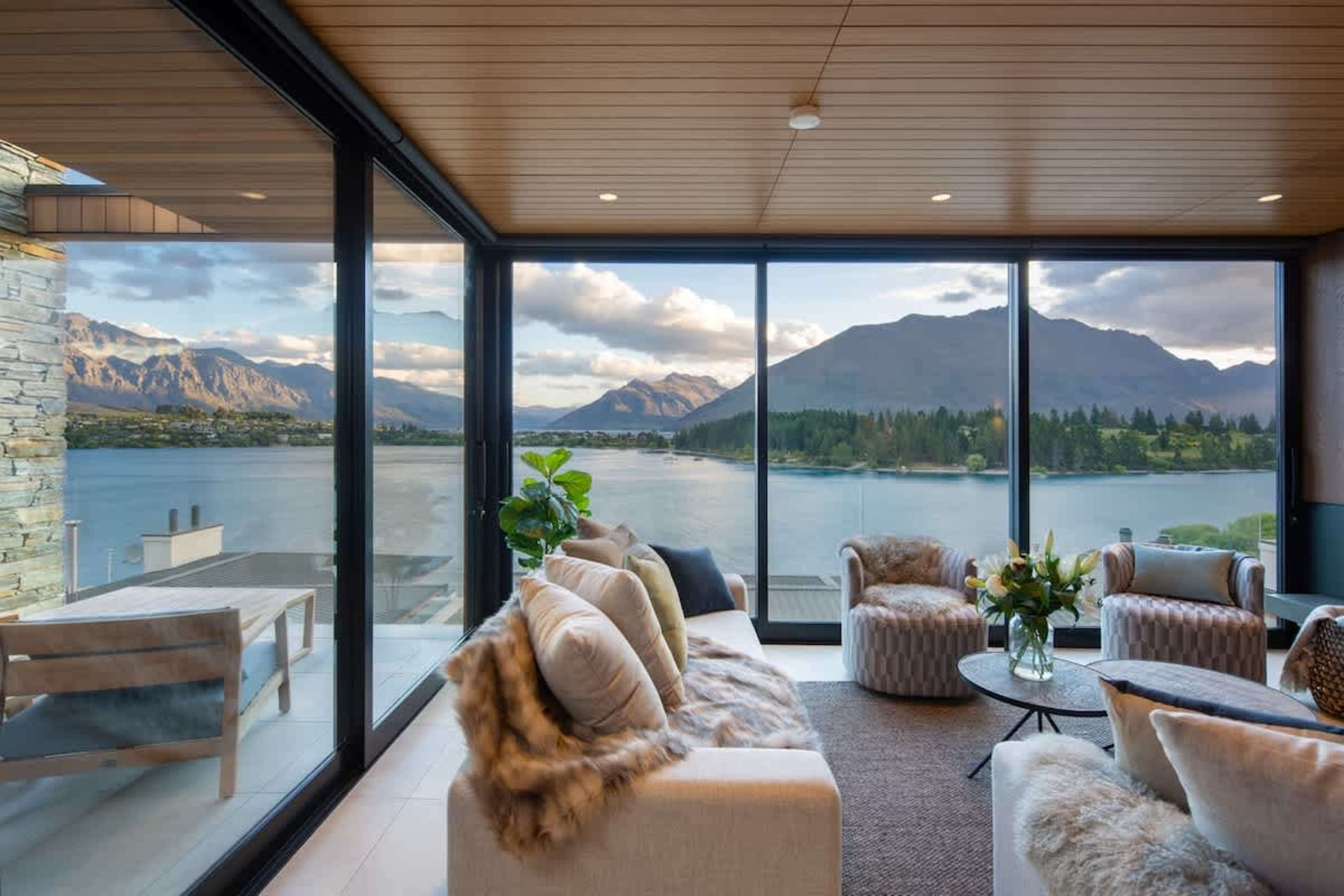 This elegant living room combines comfort and style, featuring a cozy gas fireplace, efficient air conditioning, and expansive windows with breathtaking views of Lake Wakatipu and the Remarkables. Ideal after a day of exploring Queenstown.