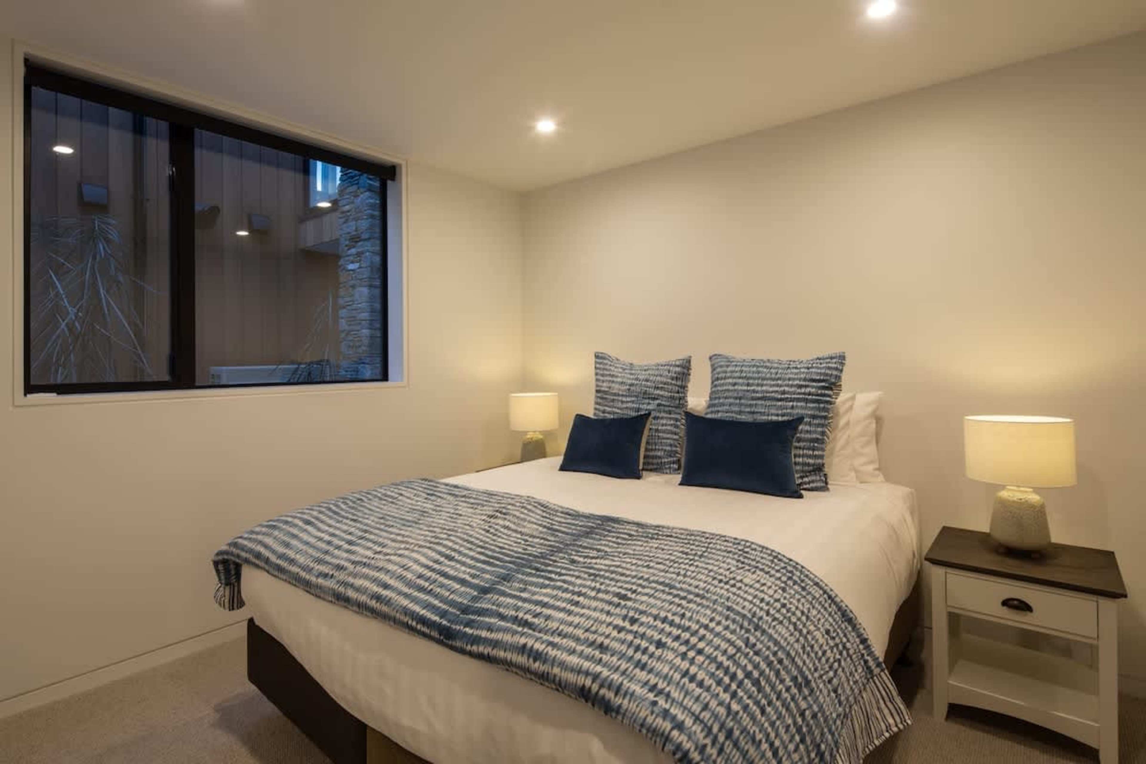 Spacious Bedroom with Views
This well-appointed fourth bedroom features a comfortable king-sized bed, elegant furnishings, and large windows that frame spectacular views of the lake and mountains. A serene and relaxing space perfect for unwinding.