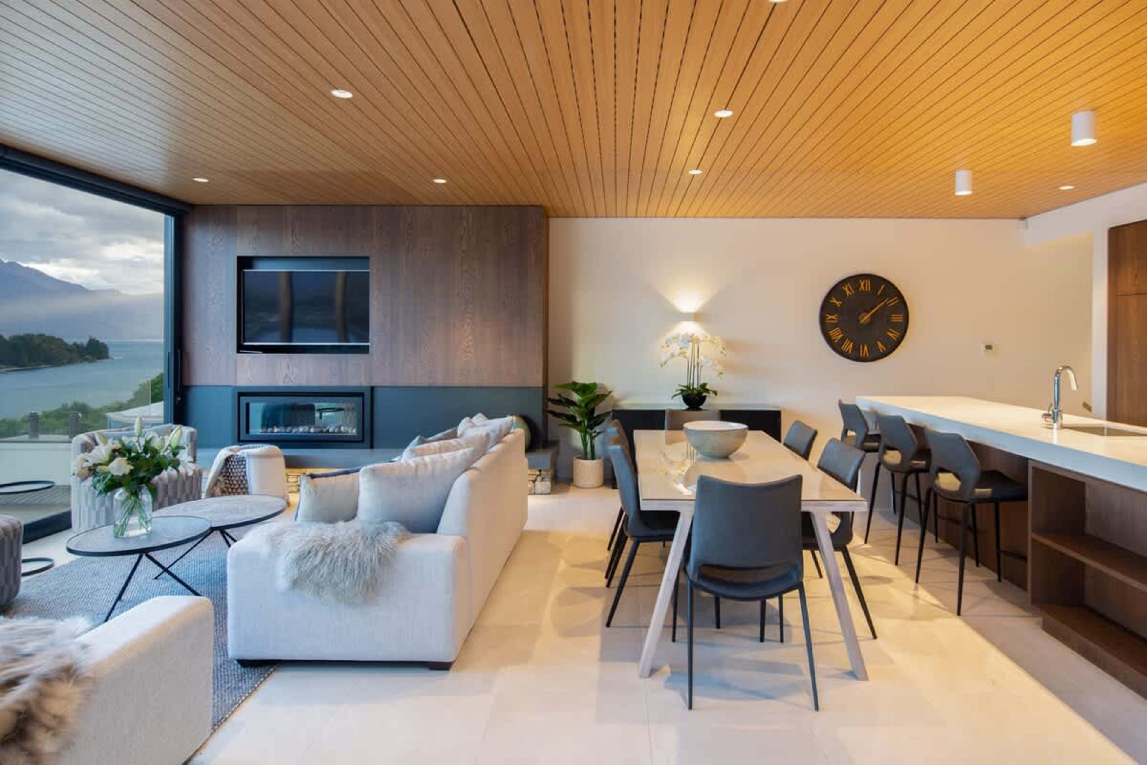 The dining area features a sleek table and comfortable seating, set against stunning lake and mountain views. Perfect for intimate dinners or family gatherings, it seamlessly connects to the kitchen and living spaces for effortless entertaining.