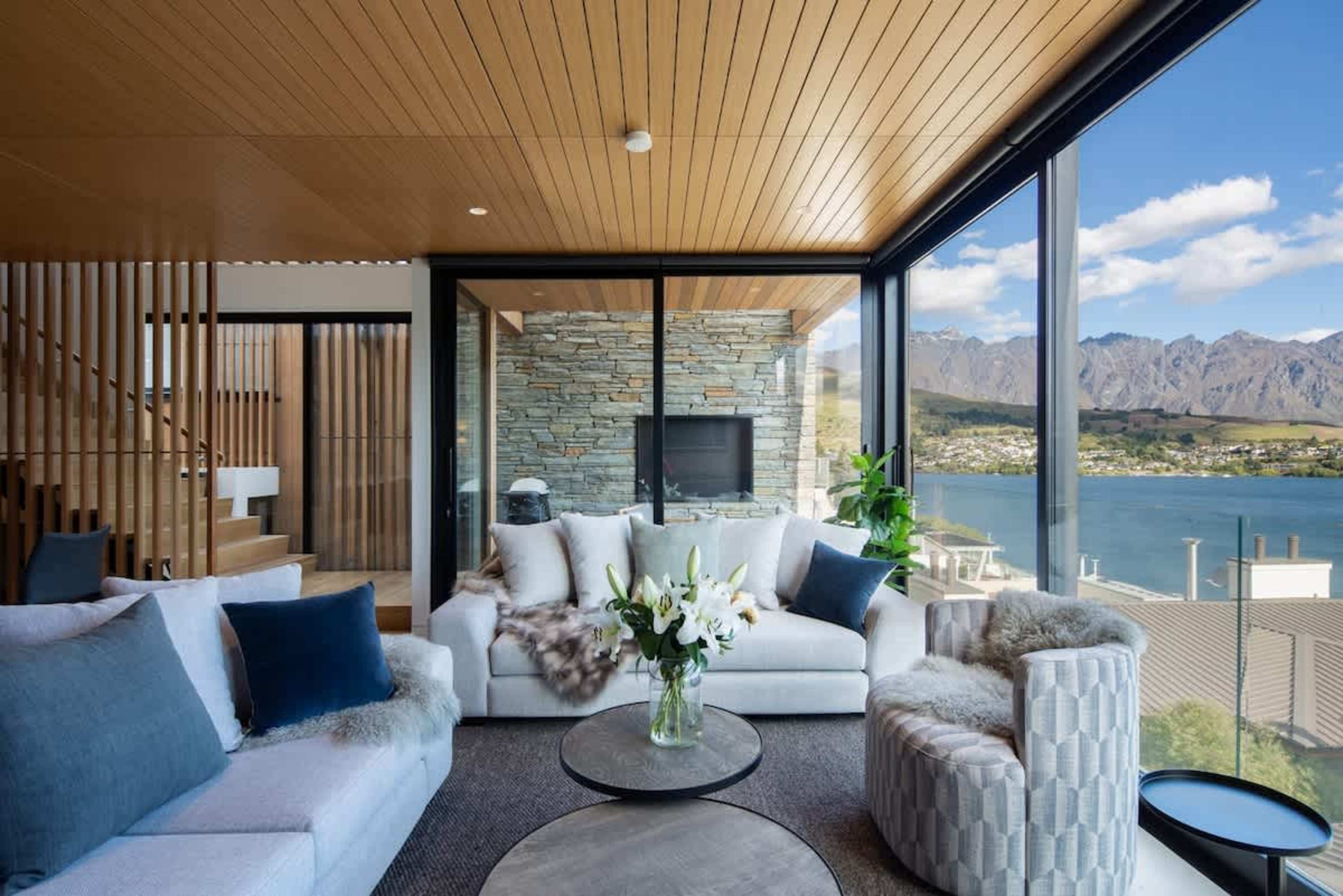 This bright and airy living room combines elegant furniture, a gas fireplace, and air conditioning for year-round comfort. Floor-to-ceiling windows bring the outdoors in, offering spectacular views of the surrounding landscape.