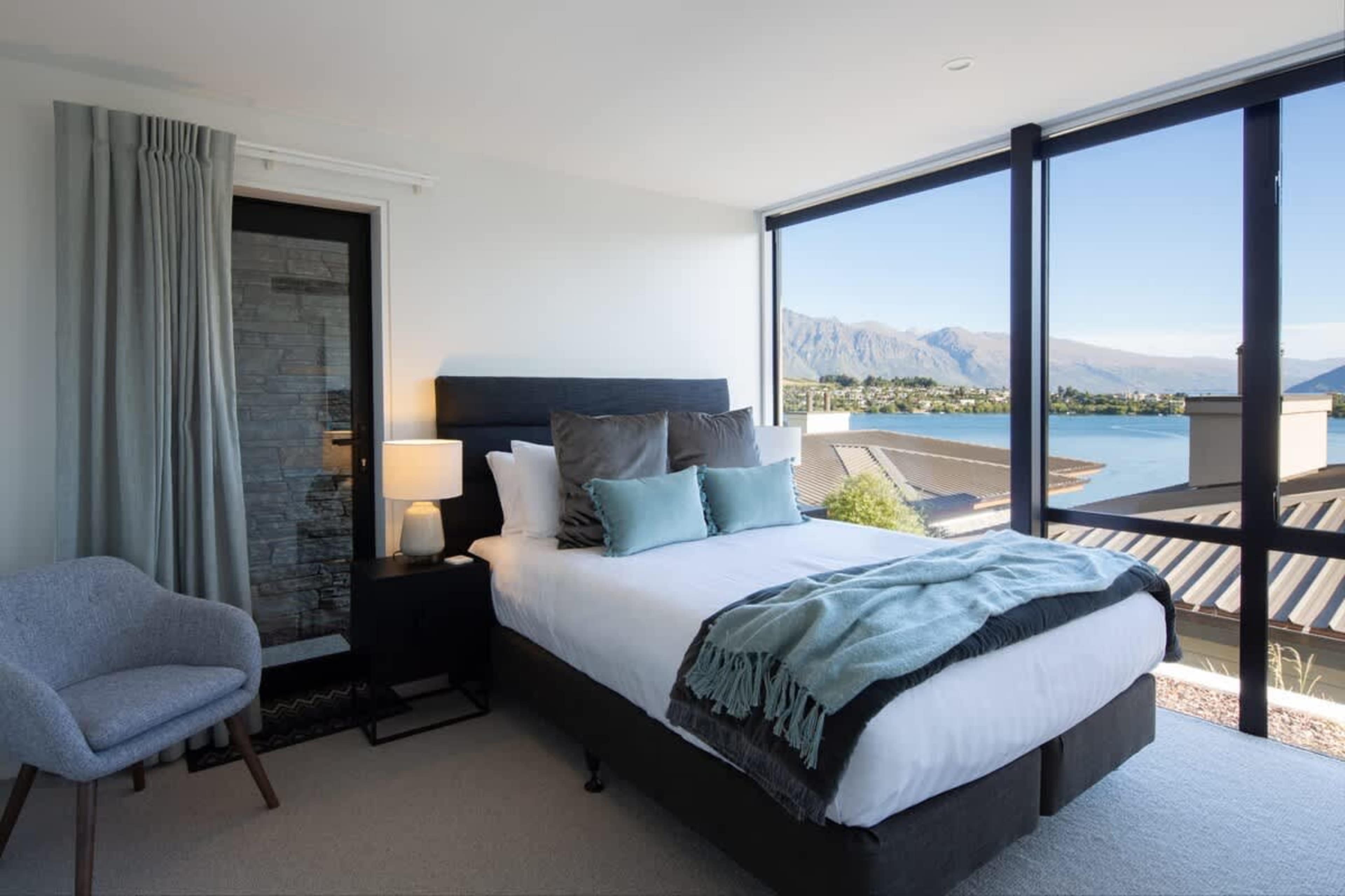 This master bedroom combines elegance and functionality with a walk-in wardrobe, modern ensuite, and stunning lake and mountain views. Designed for relaxation, the space is filled with natural light and luxurious furnishings for a perfect retreat.