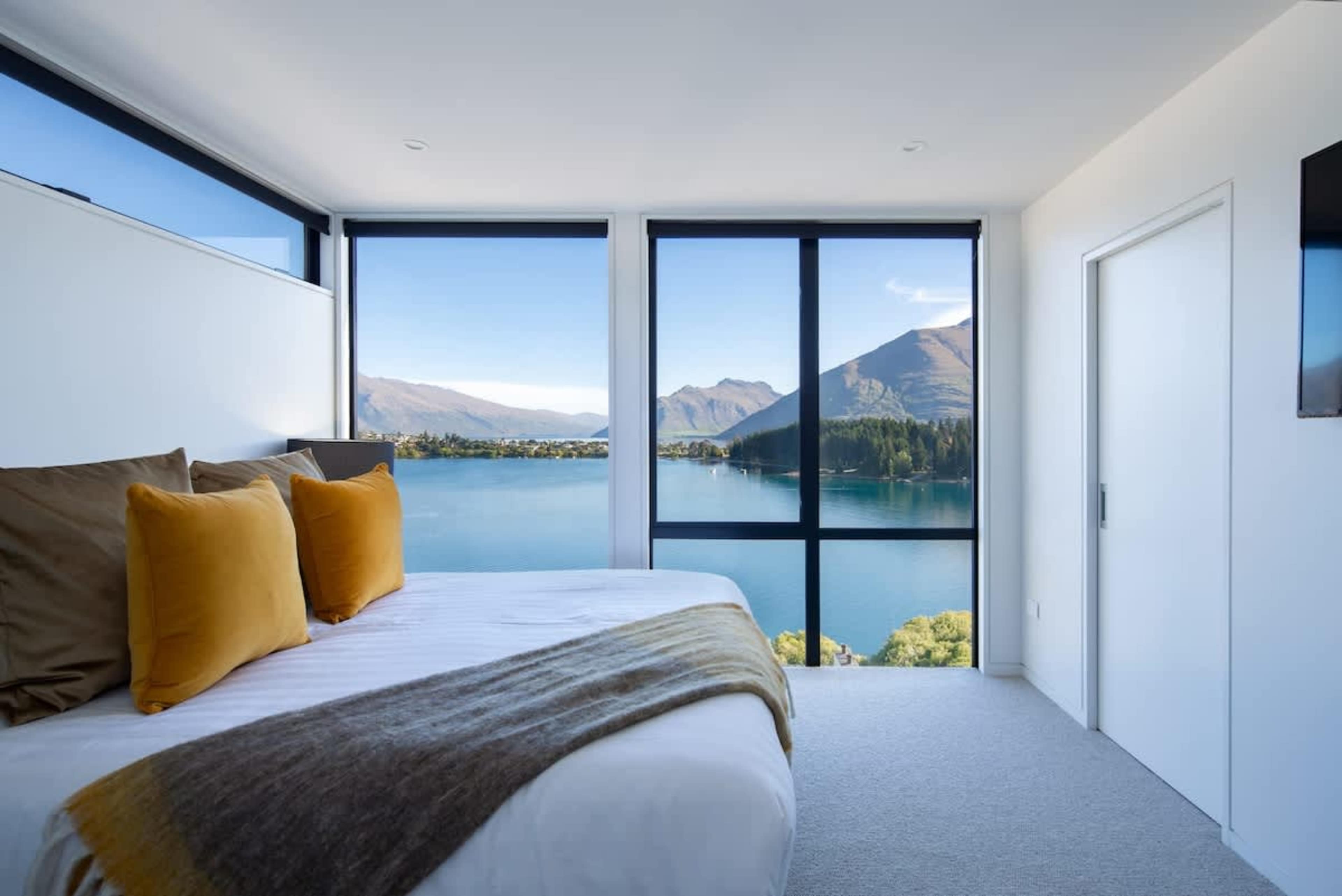 Designed for comfort, this second master suite includes a private ensuite, a walk-in wardrobe, and breathtaking views of the lake and mountains. With stylish decor and natural light flooding the room, it’s the perfect space to unwind in luxury.