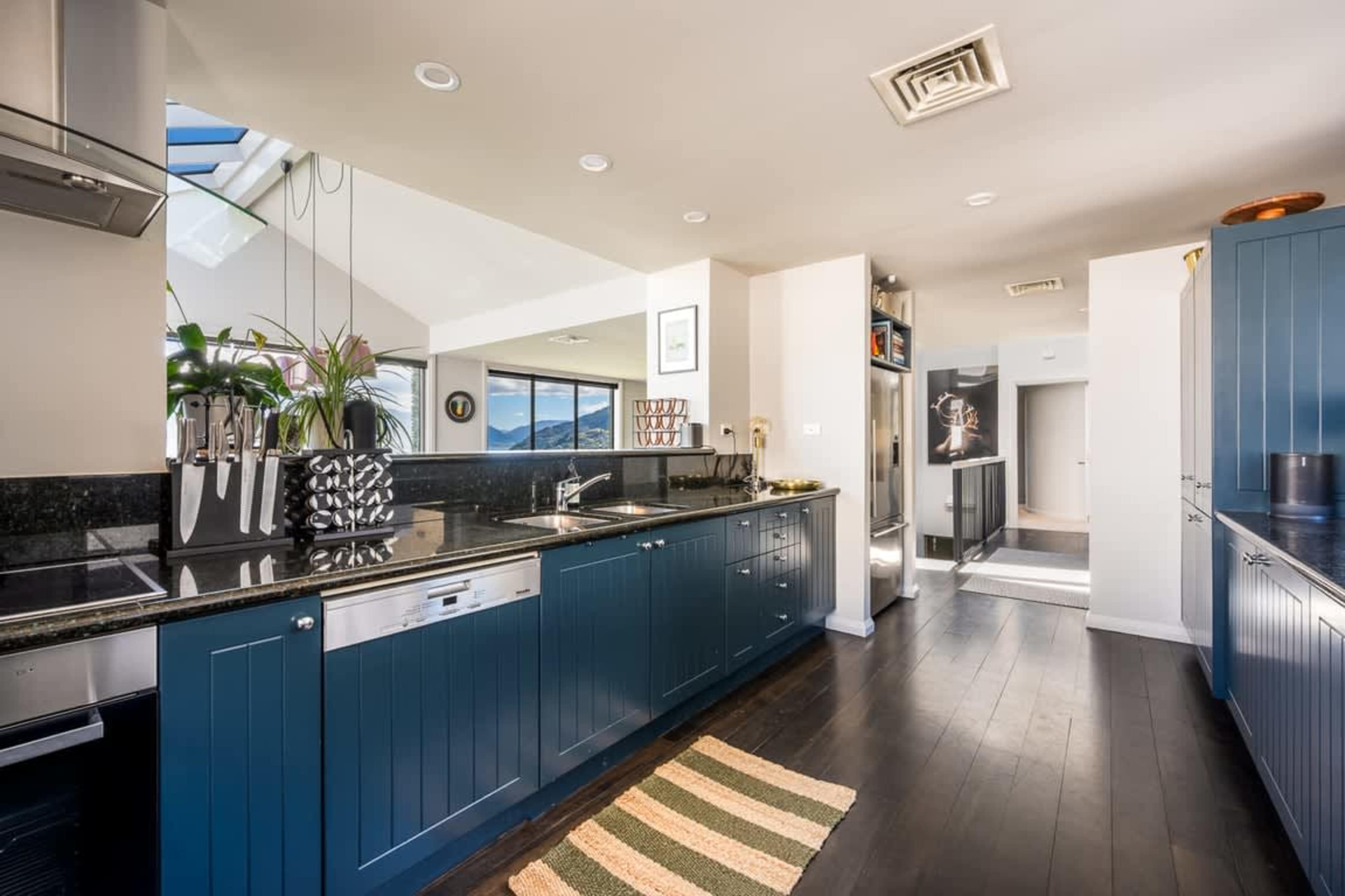 Modern Entertainer’s Kitchen Prepare meals with ease in the fully equipped kitchen, designed for style and functionality, with seamless flow to the outdoor patio.