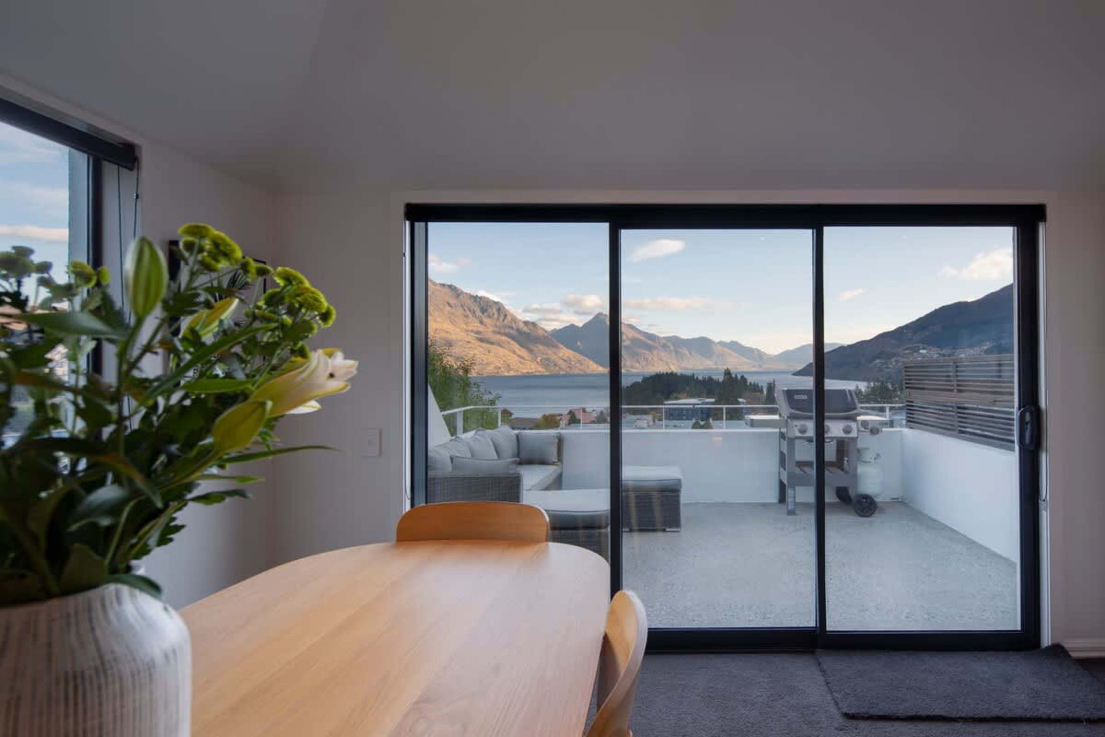 Dine with a View: Elegant dining area with seating for six, perfectly positioned to enjoy stunning lake and mountain views through expansive windows.