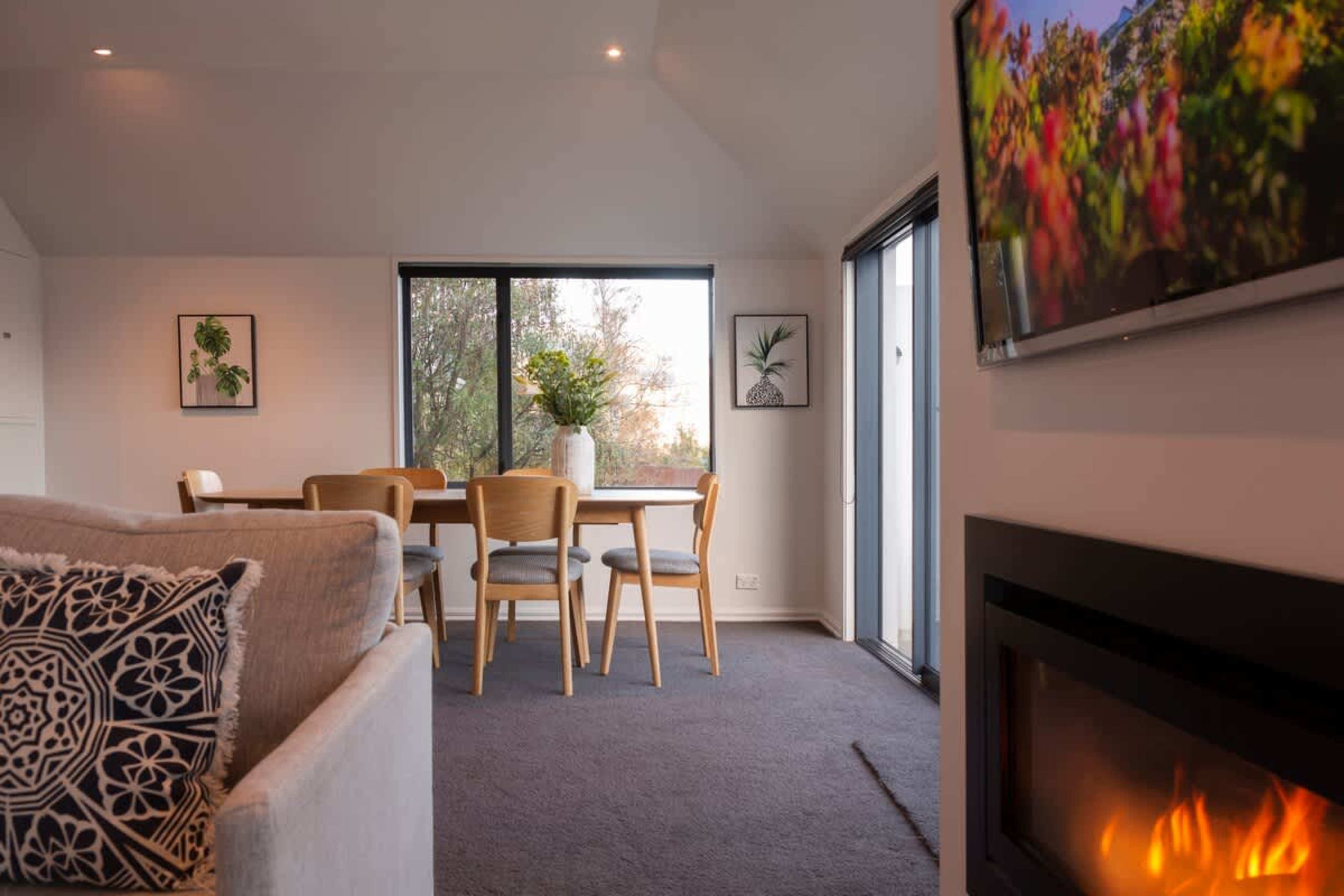 Family-Friendly Relaxation: Spacious living room with a gas fire, air conditioning, and jaw-dropping lake views. Perfect for relaxing after Queenstown adventures.