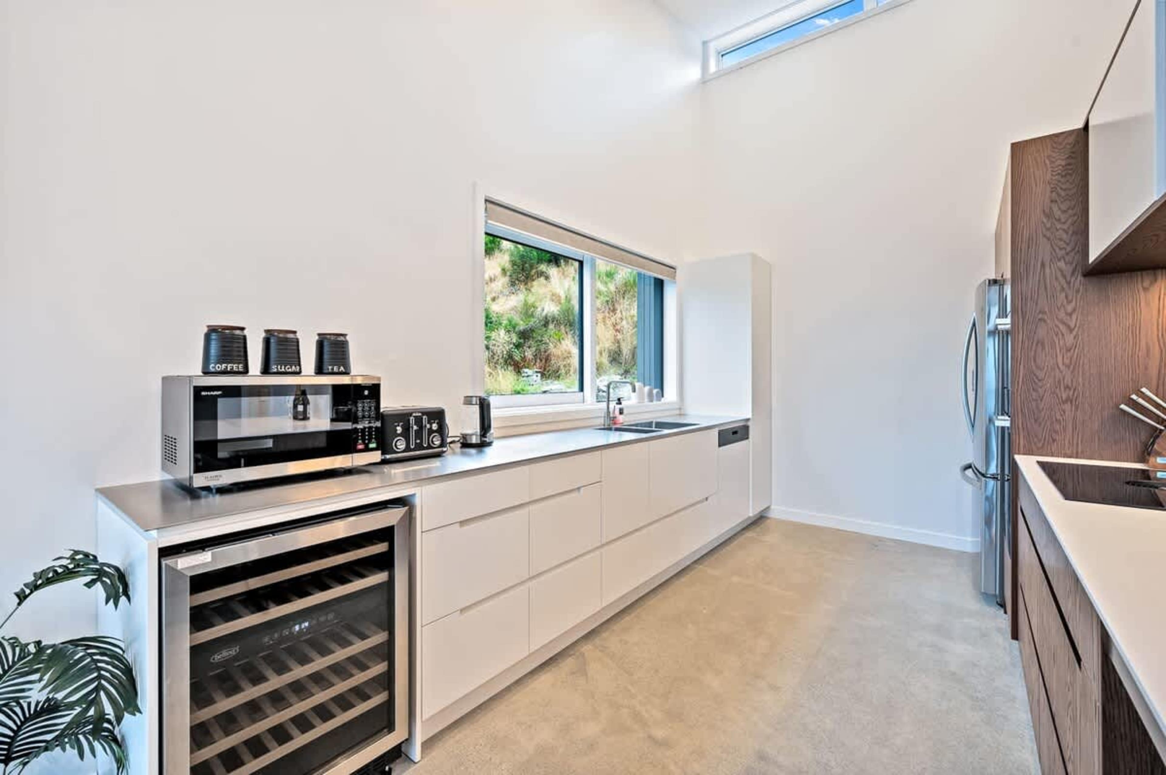 The modern kitchen is fully equipped with high-end appliances, including a wine fridge and coffee machine, offering seamless indoor-outdoor flow to the deck with stunning views of the lake and mountains.
Indulgence in luxury accommodation, NZ
