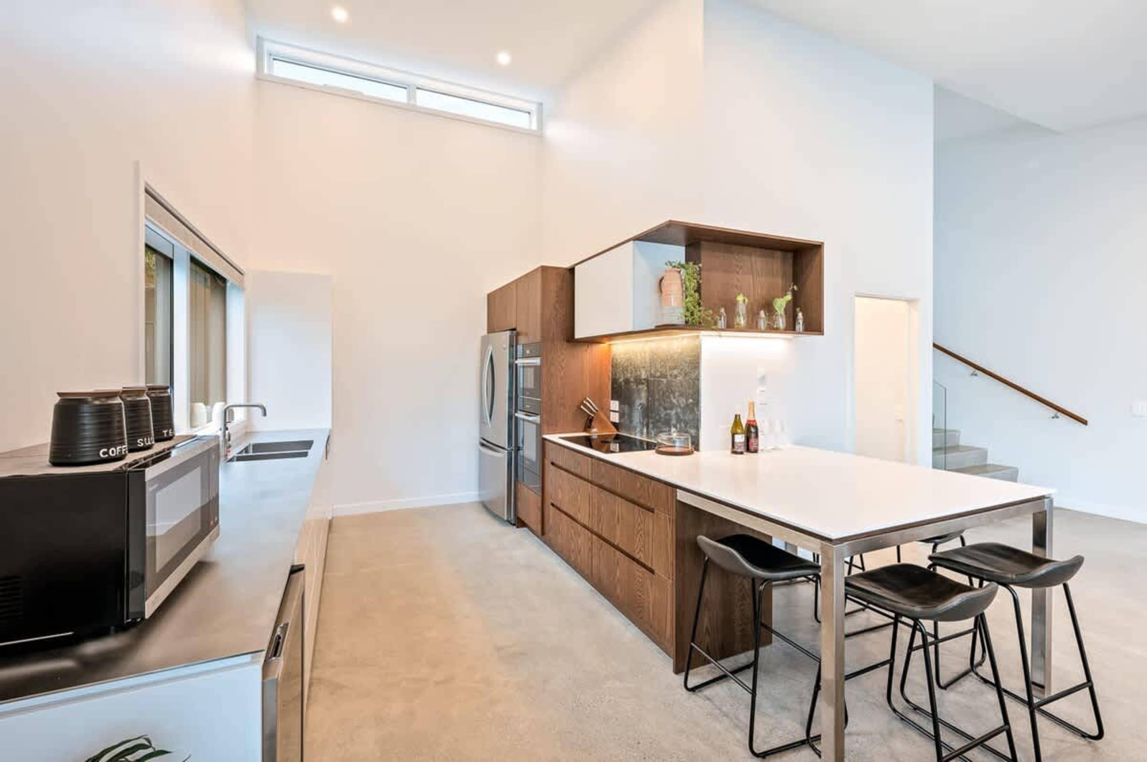This sleek kitchen features top-of-the-line appliances, a wine fridge, and a coffee machine, perfectly complemented by easy access to the deck, where you can enjoy breathtaking views while dining.