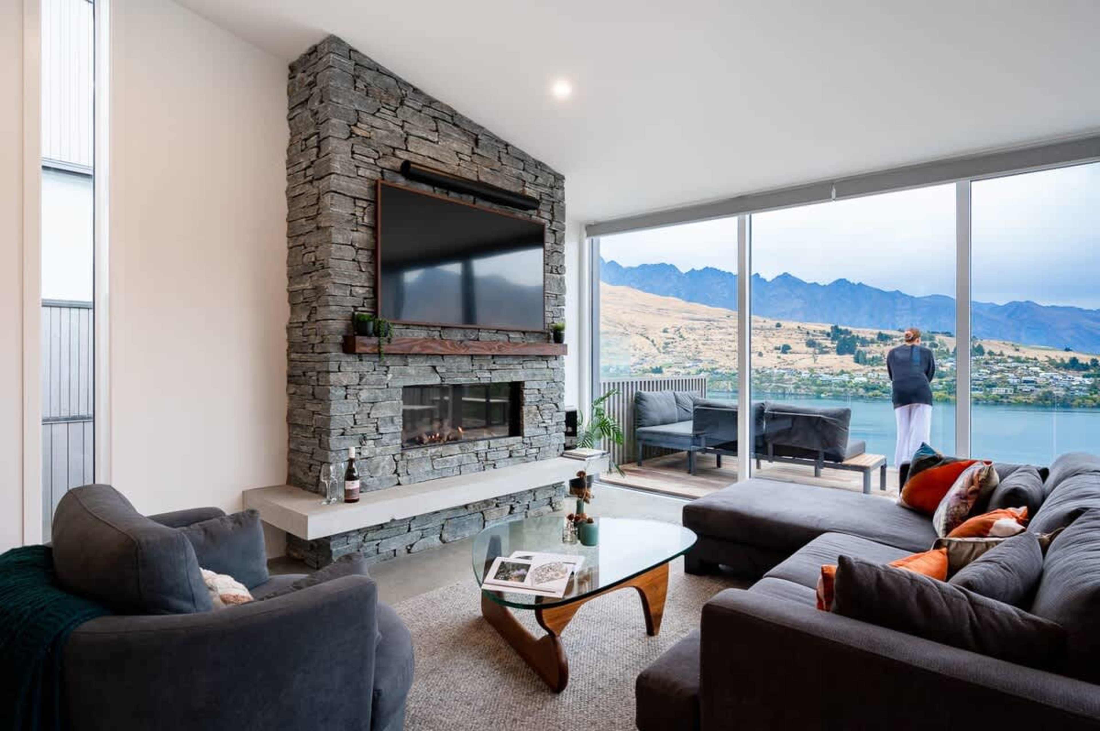 The living room offers a perfect blend of comfort and luxury with a gas fireplace, plush seating, and incredible views, making it an ideal spot to unwind and enjoy the scenery.
