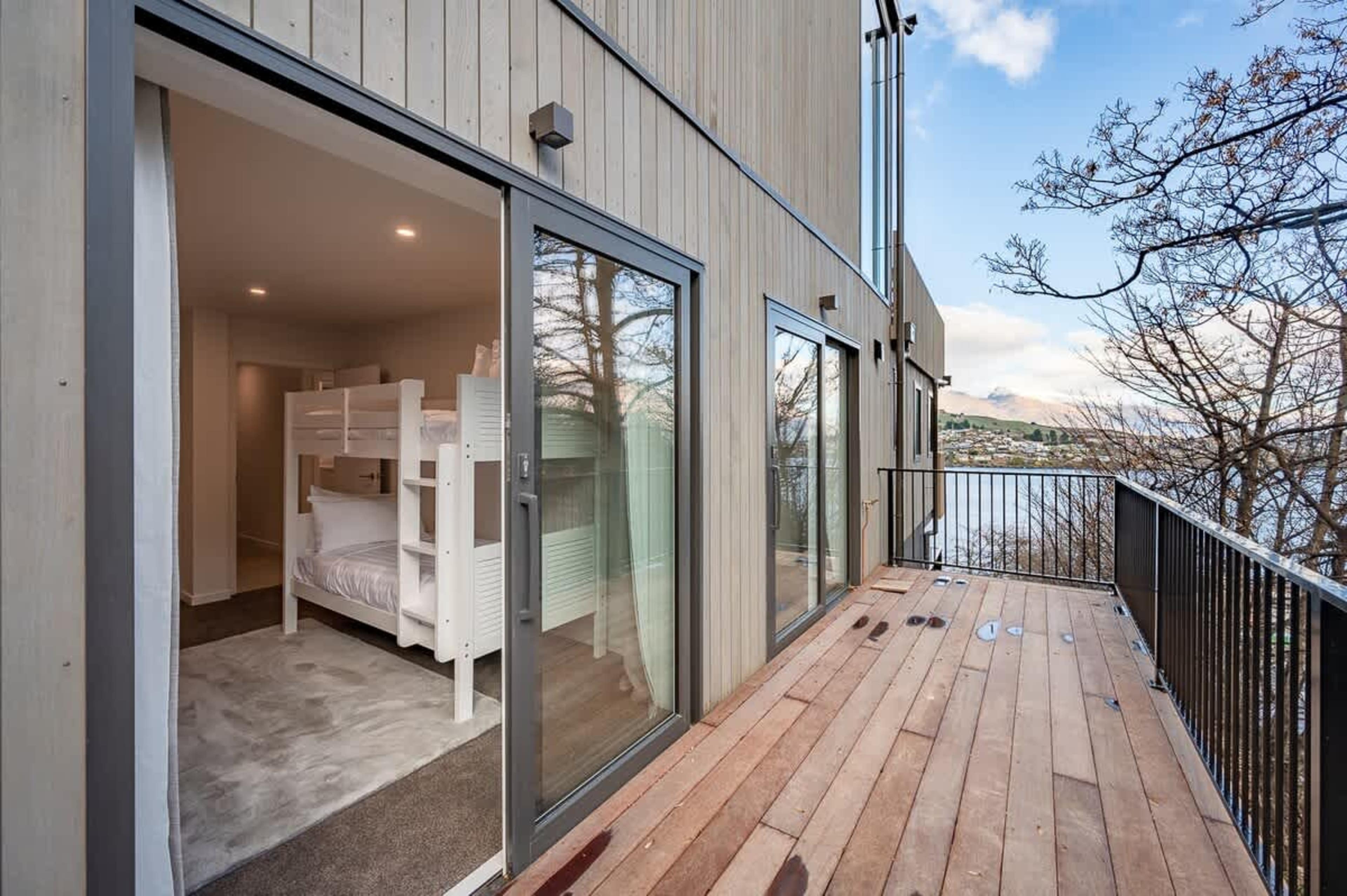 This spacious balcony features a BBQ and cozy seating, providing the perfect place to enjoy a glass of wine while soaking in panoramic views of the lake and mountains.