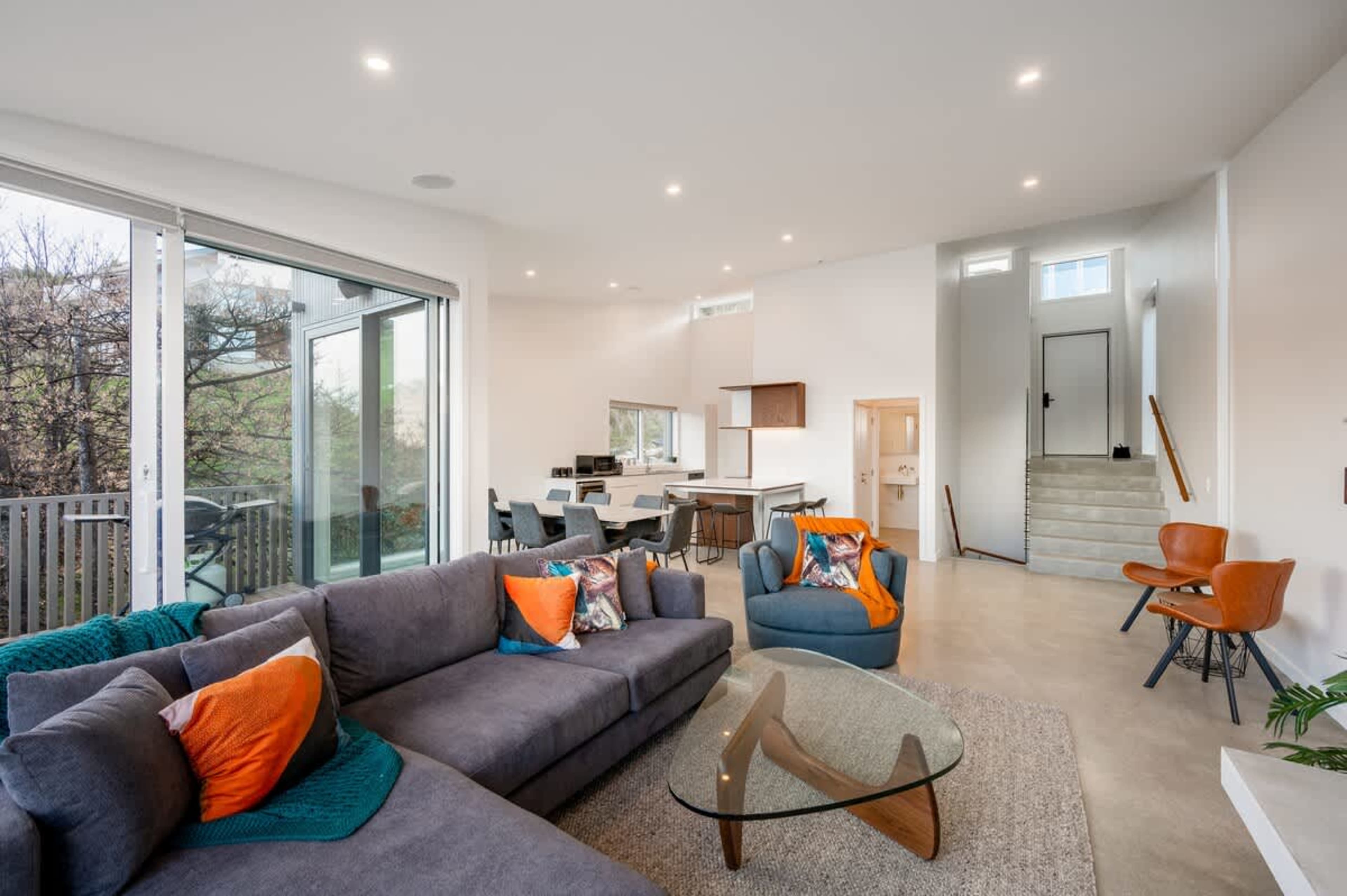 This elegant living room offers a gas fireplace, plush seating, and floor-to-ceiling windows that showcase panoramic lake and mountain views, creating a serene atmosphere for relaxation.
