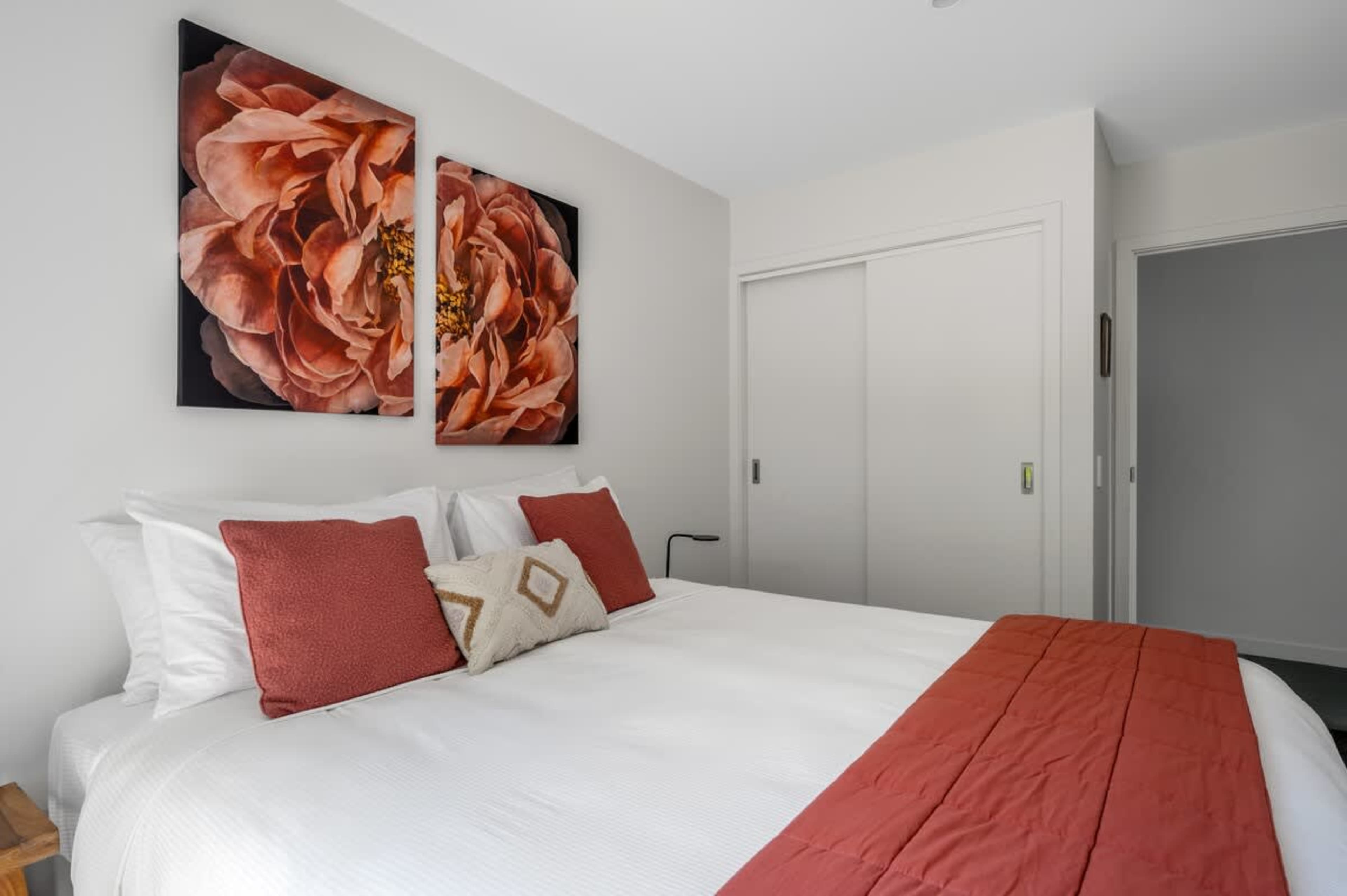This inviting third bedroom features a king-sized bed, modern furnishings, and a serene atmosphere, perfect for relaxing with easy access to the outdoor deck and breathtaking views.