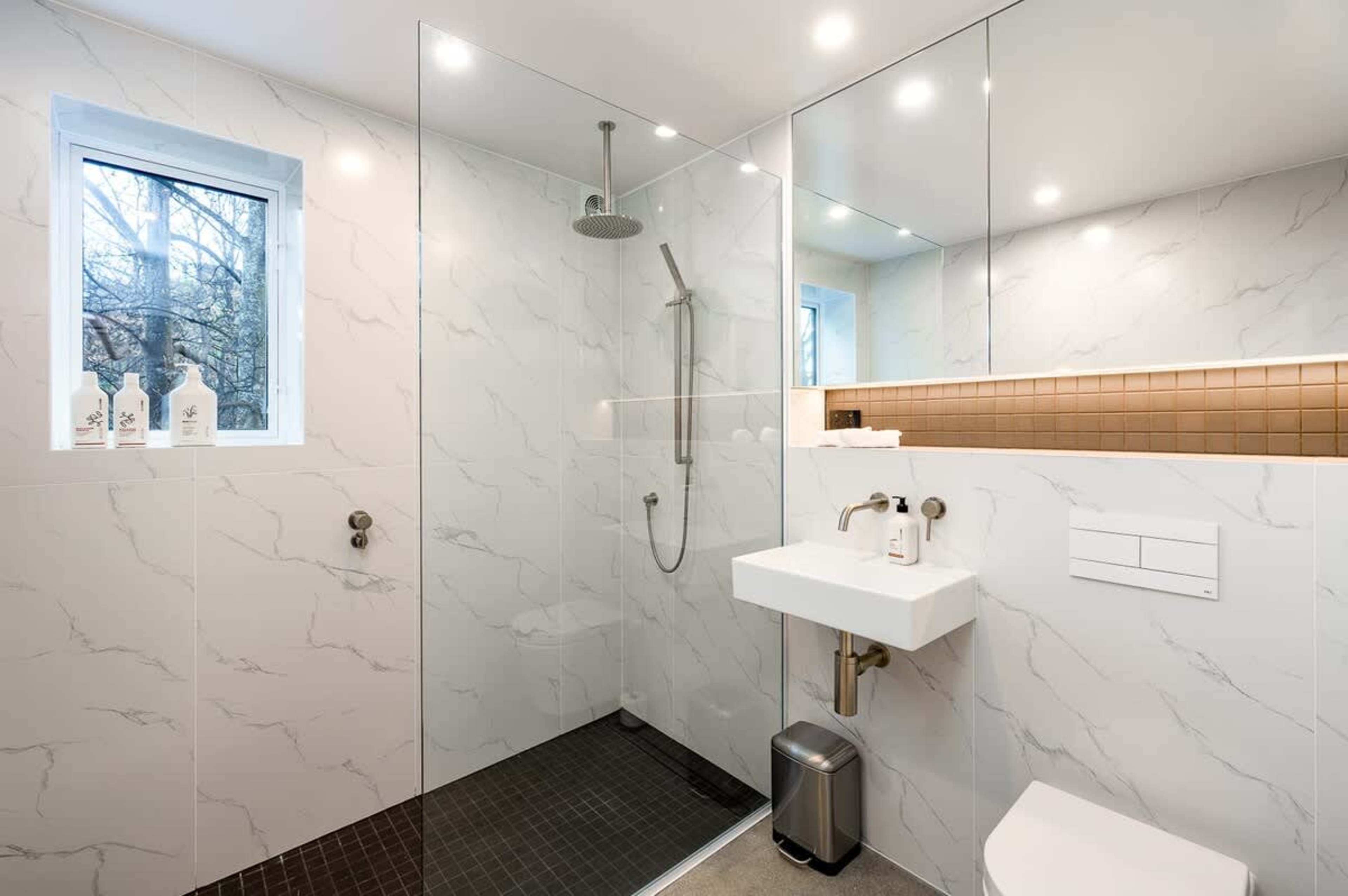 The master bathroom features luxurious heated floors, towel rails, and a selection of Ashley & Co toiletries, offering both comfort and style in a beautifully designed space.