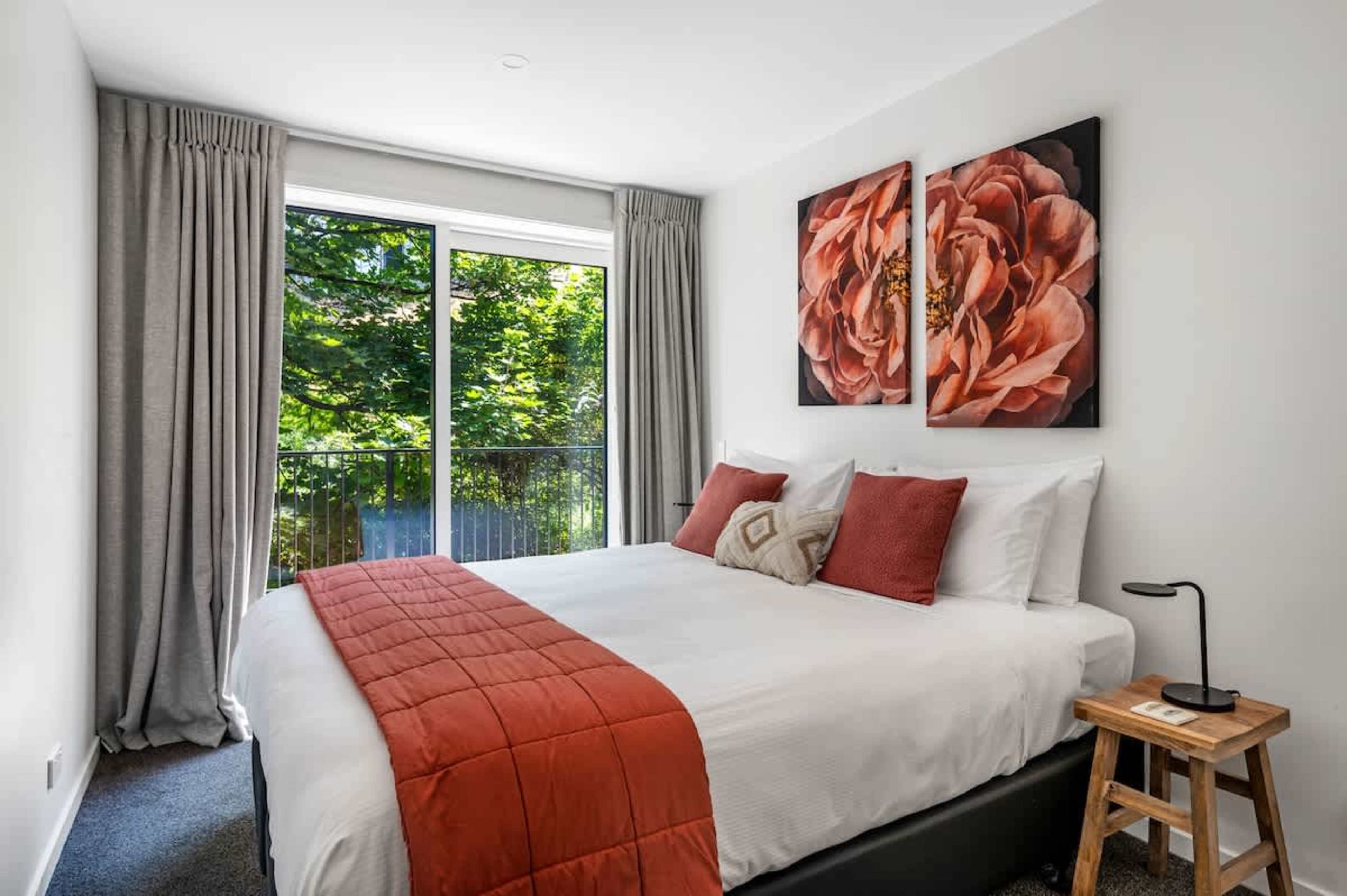 The third bedroom offers a spacious king-sized bed, contemporary decor, and large windows that fill the room with natural light and stunning views of the lake and mountains.
