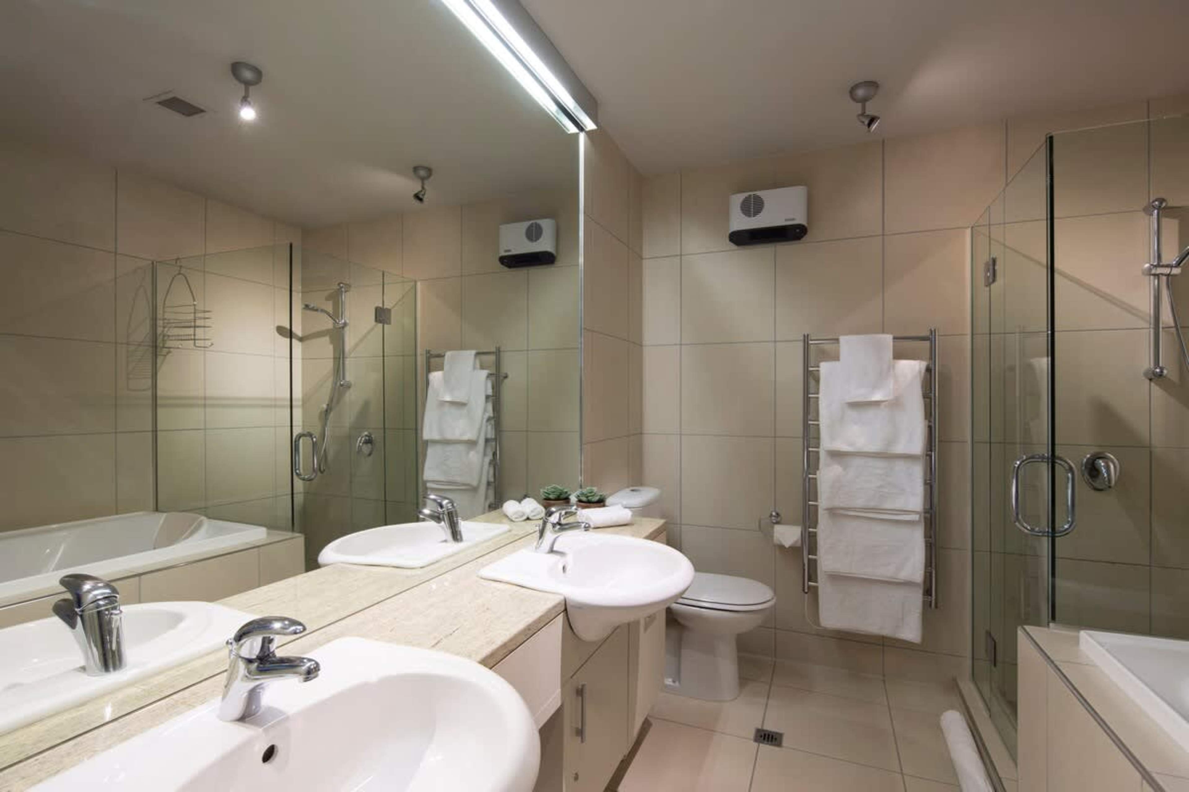 Luxurious Master Bathroom: Indulge in the spacious master bathroom featuring a relaxing bath, walk-in shower, heated floors, and premium Ashley & Co toiletries for a spa-like experience.