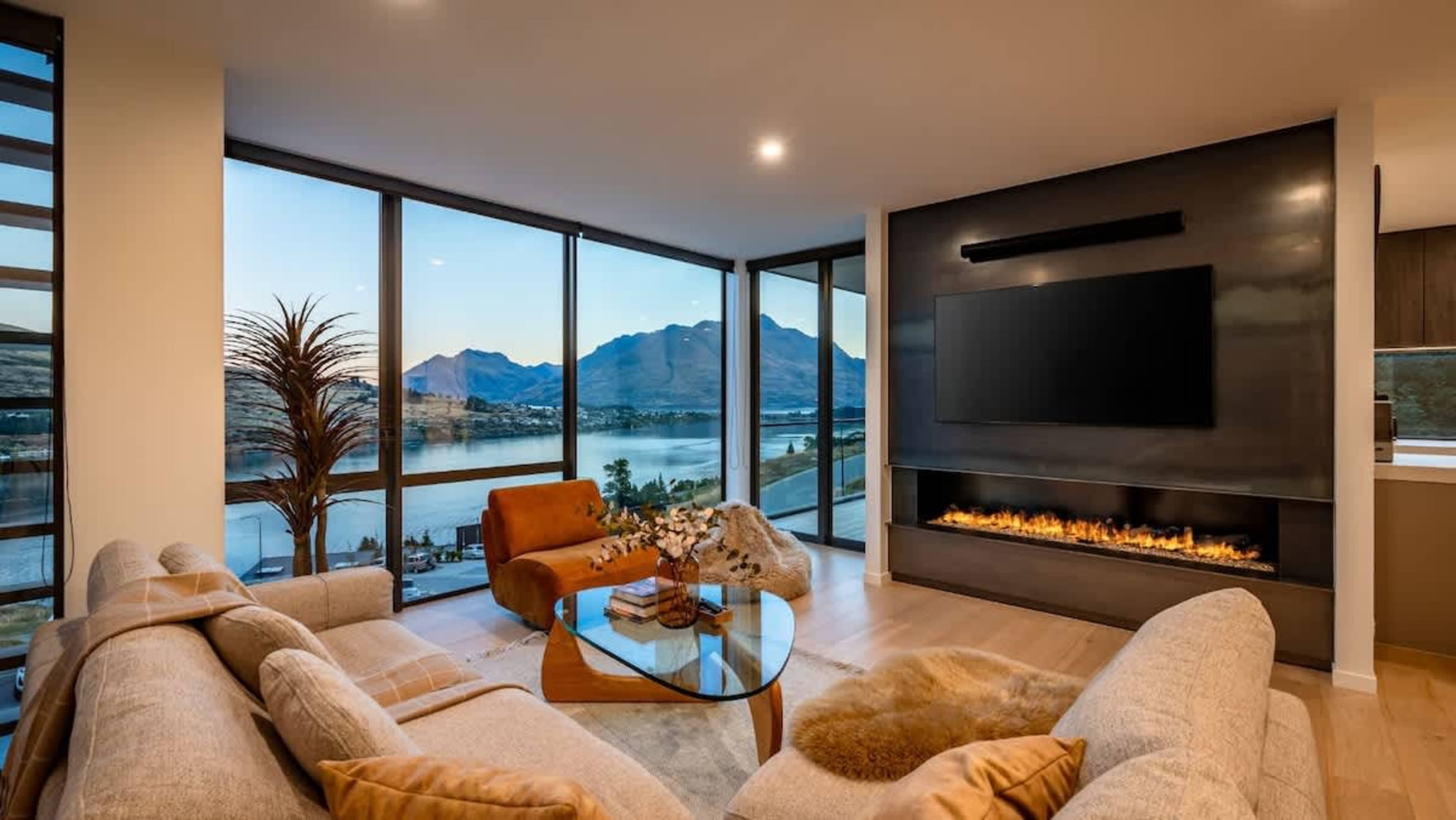 This brand-new, super-luxe 4-bedroom villa features an expansive living room with floor-to-ceiling windows showcasing breathtaking lake and mountain views. Enjoy the warmth of the indoor fireplace and the comfort of heated floors.