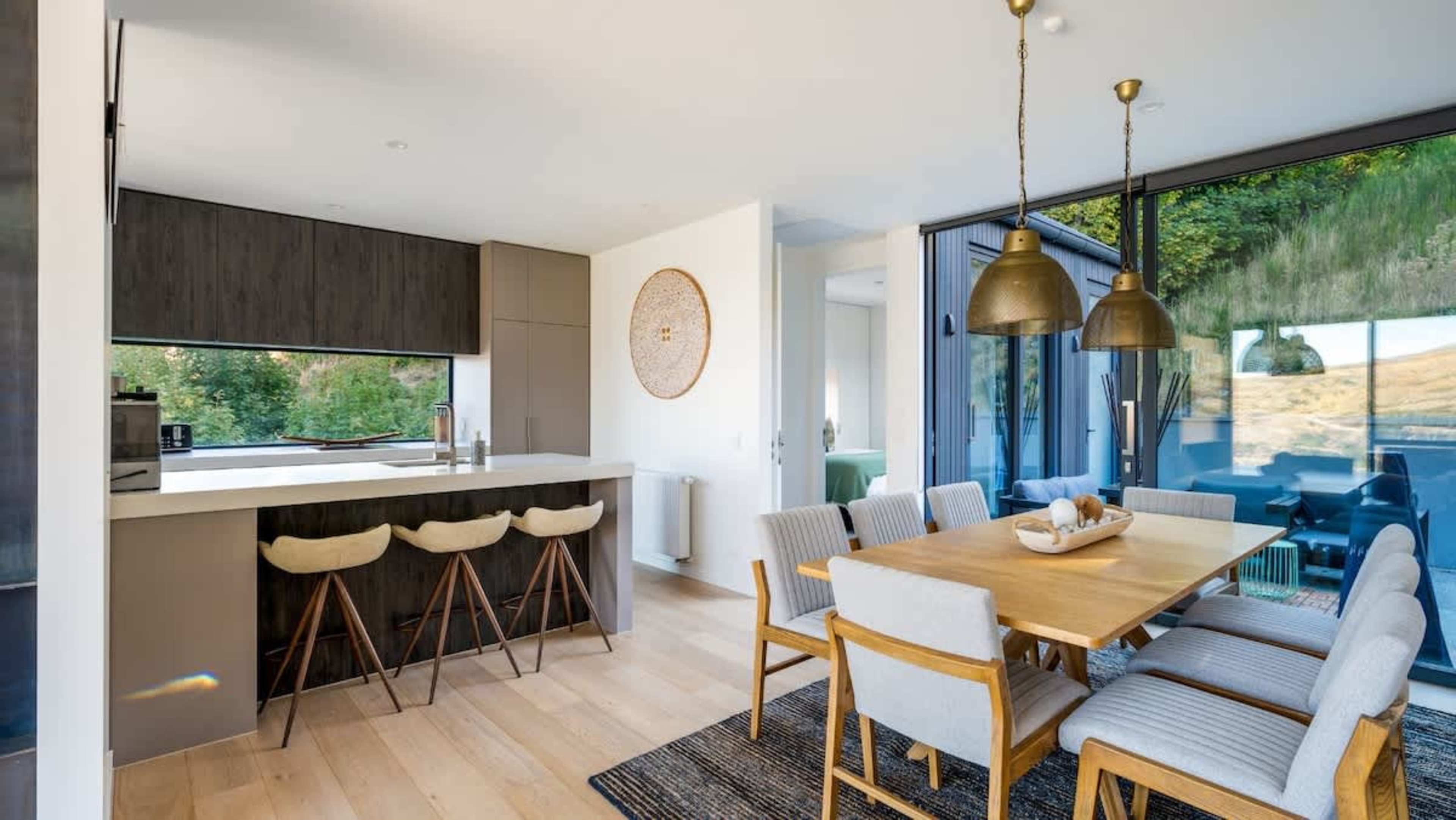 The dining room combines sophistication and comfort, with a large table for eight and panoramic views, creating a perfect setting for dining and entertaining in style.
Spacious open-plan kitchen in our luxury accommodation, NZ