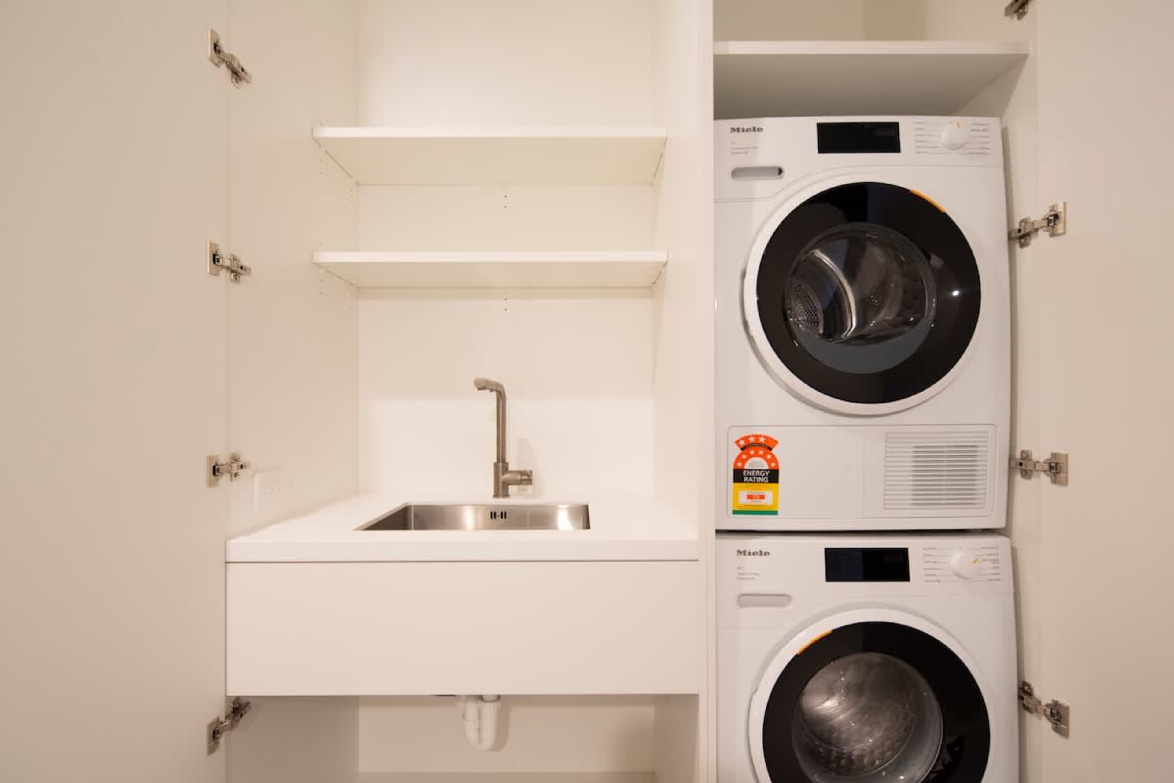 The convenient laundry area is equipped with a washer, dryer, and ample storage space, ensuring easy access to clean linens and clothes during your stay.