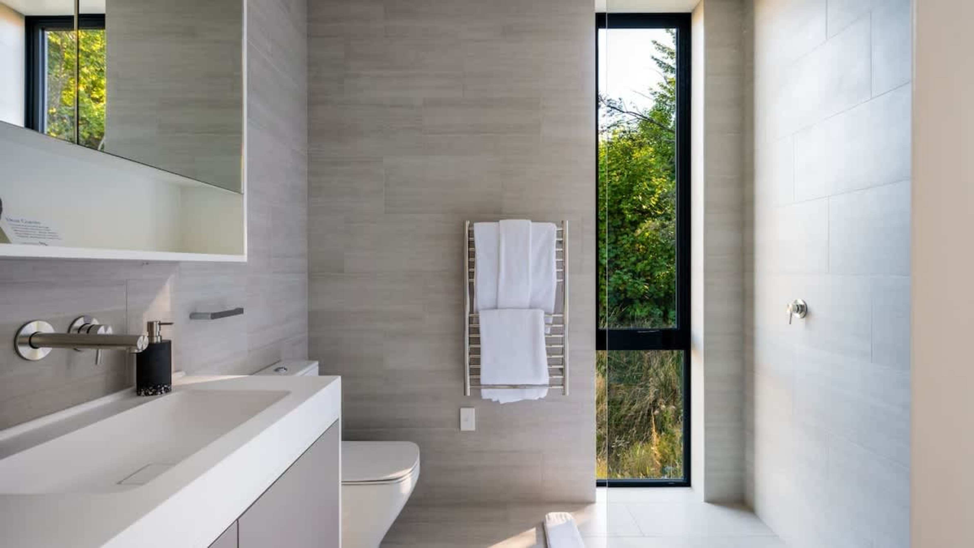 The master ensuite features a luxurious walk-in shower, heated floors, towel rails, and elegant finishes, offering a spa-like experience with a sleek alleyway for added space.