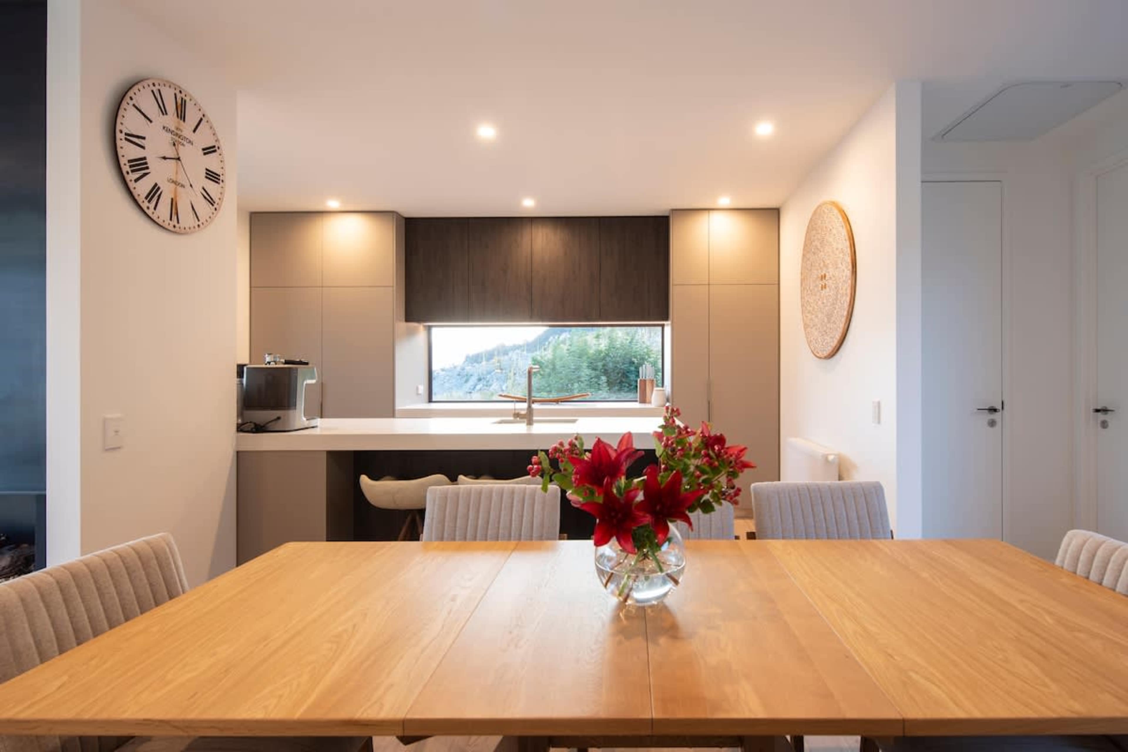 This spacious dining area offers seating for eight, with a stylish design and a backdrop of breathtaking lake and mountain vistas, ideal for memorable meals.