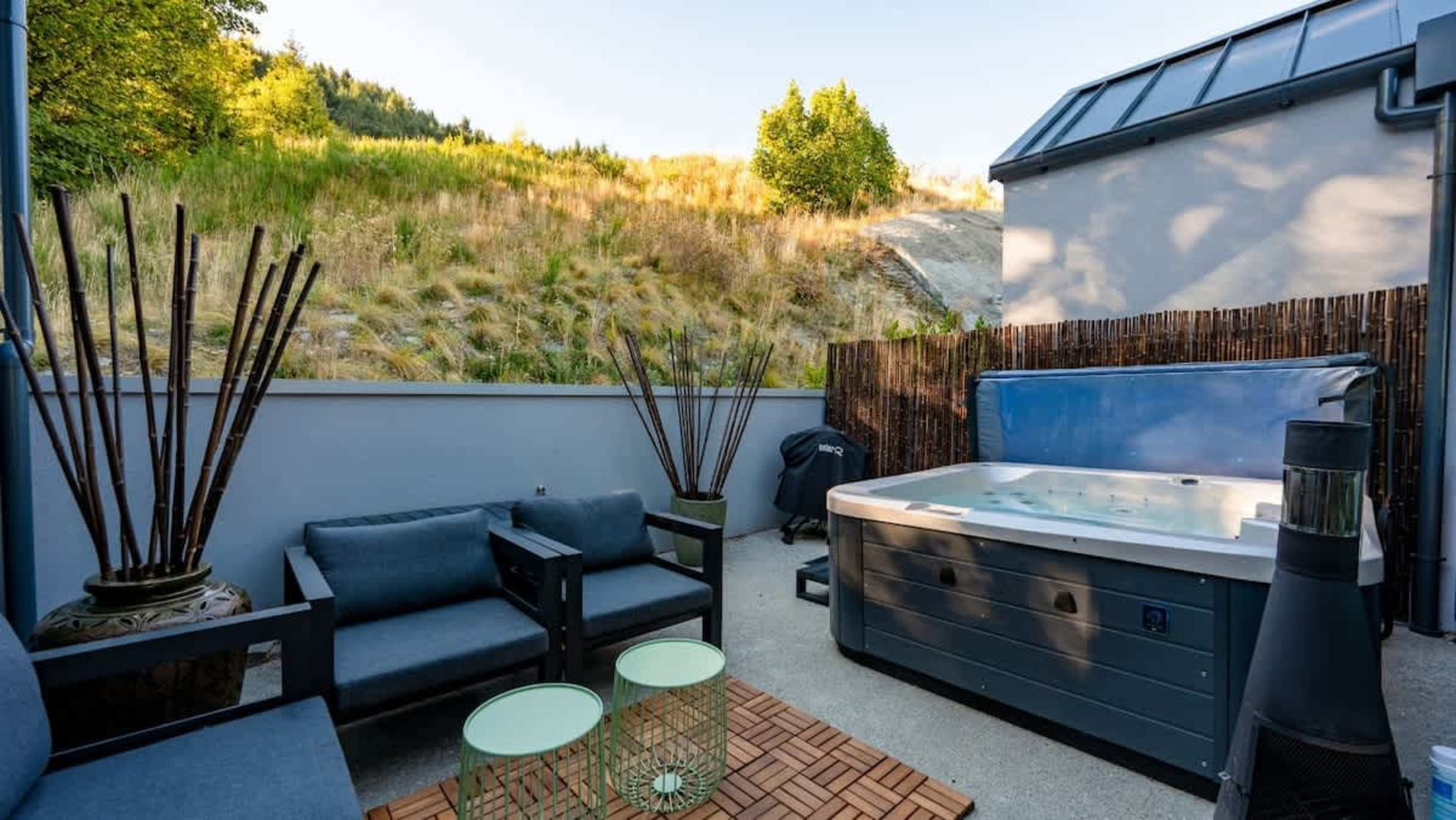 Enjoy the back deck area with a hot tub, outdoor dining set, and BBQ, offering a perfect spot to unwind or host a BBQ while taking in the fresh air.