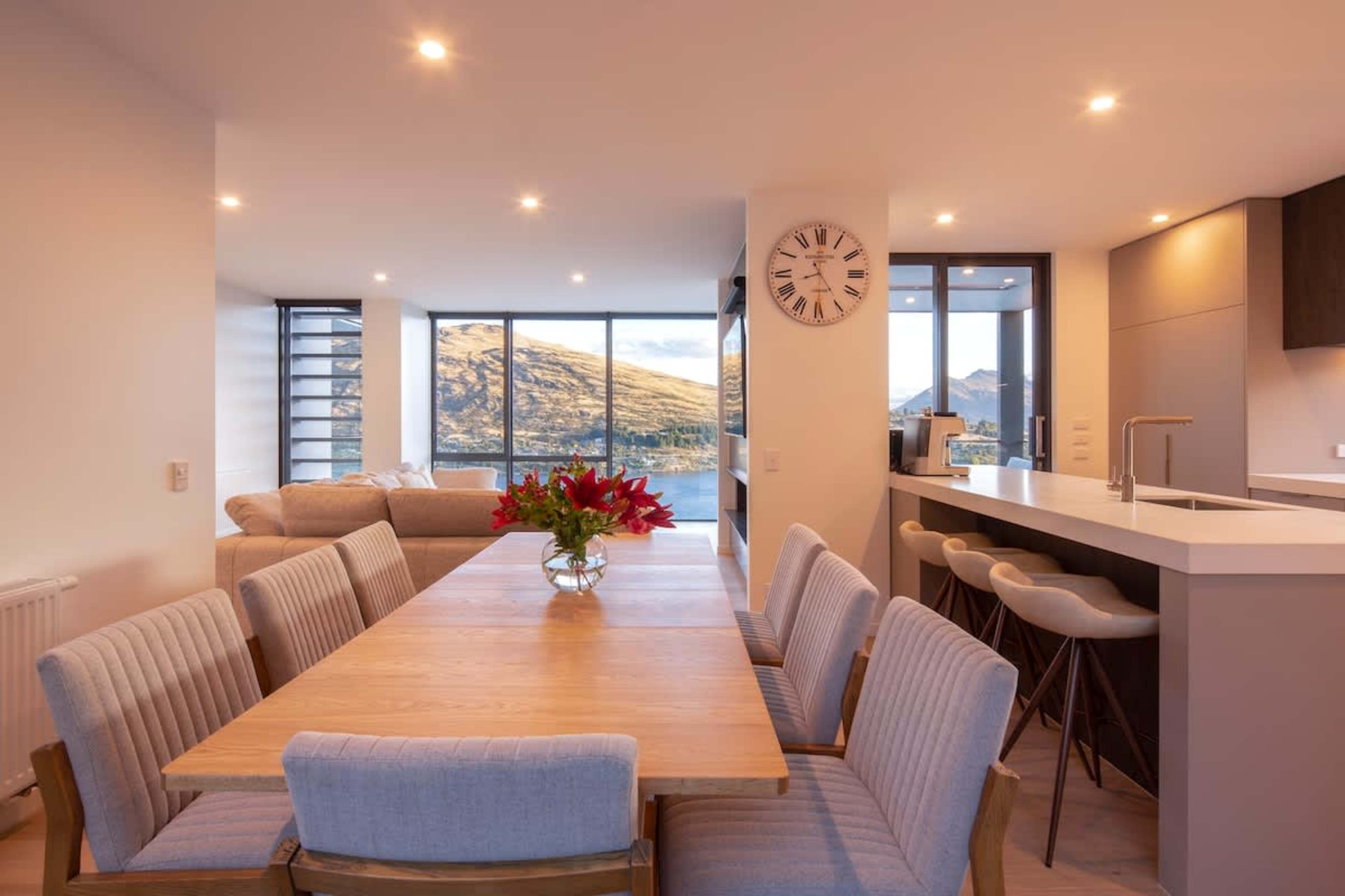 The elegant dining room features a large table for eight, framed by stunning lake and mountain views—perfect for intimate dinners or gatherings with friends and family.