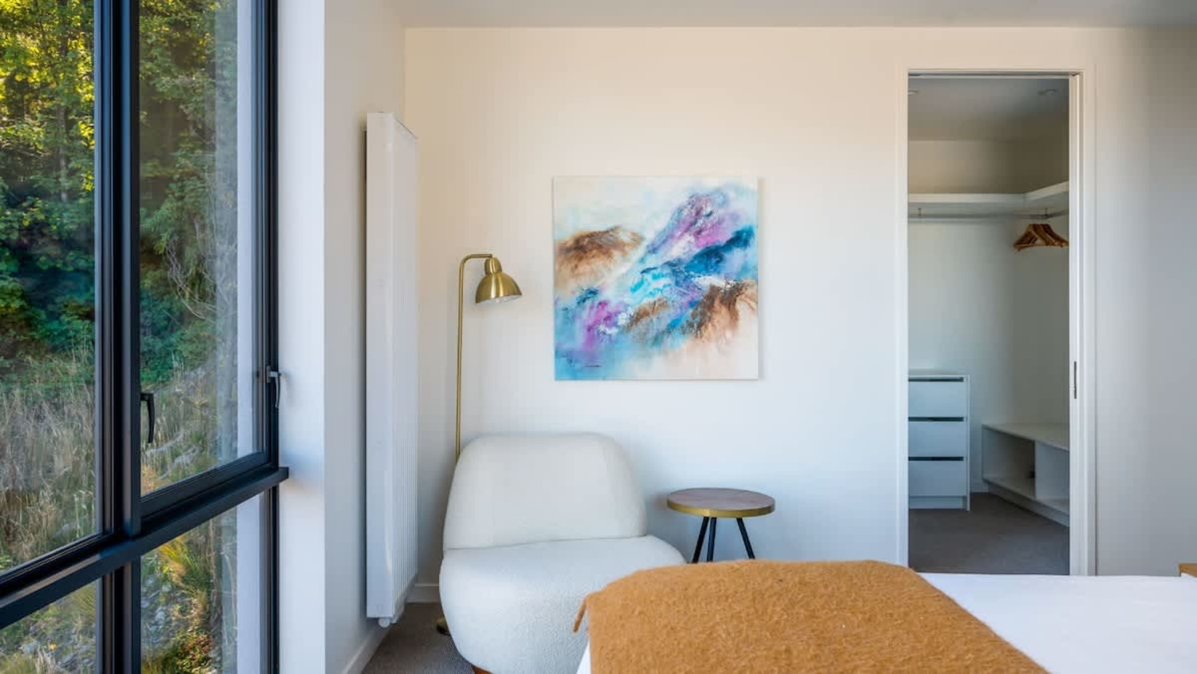 The master bedroom is a tranquil haven, featuring a king-sized bed, an ensuite with a rain shower, and a large wardrobe, along with breathtaking views of the surrounding mountains and lake.