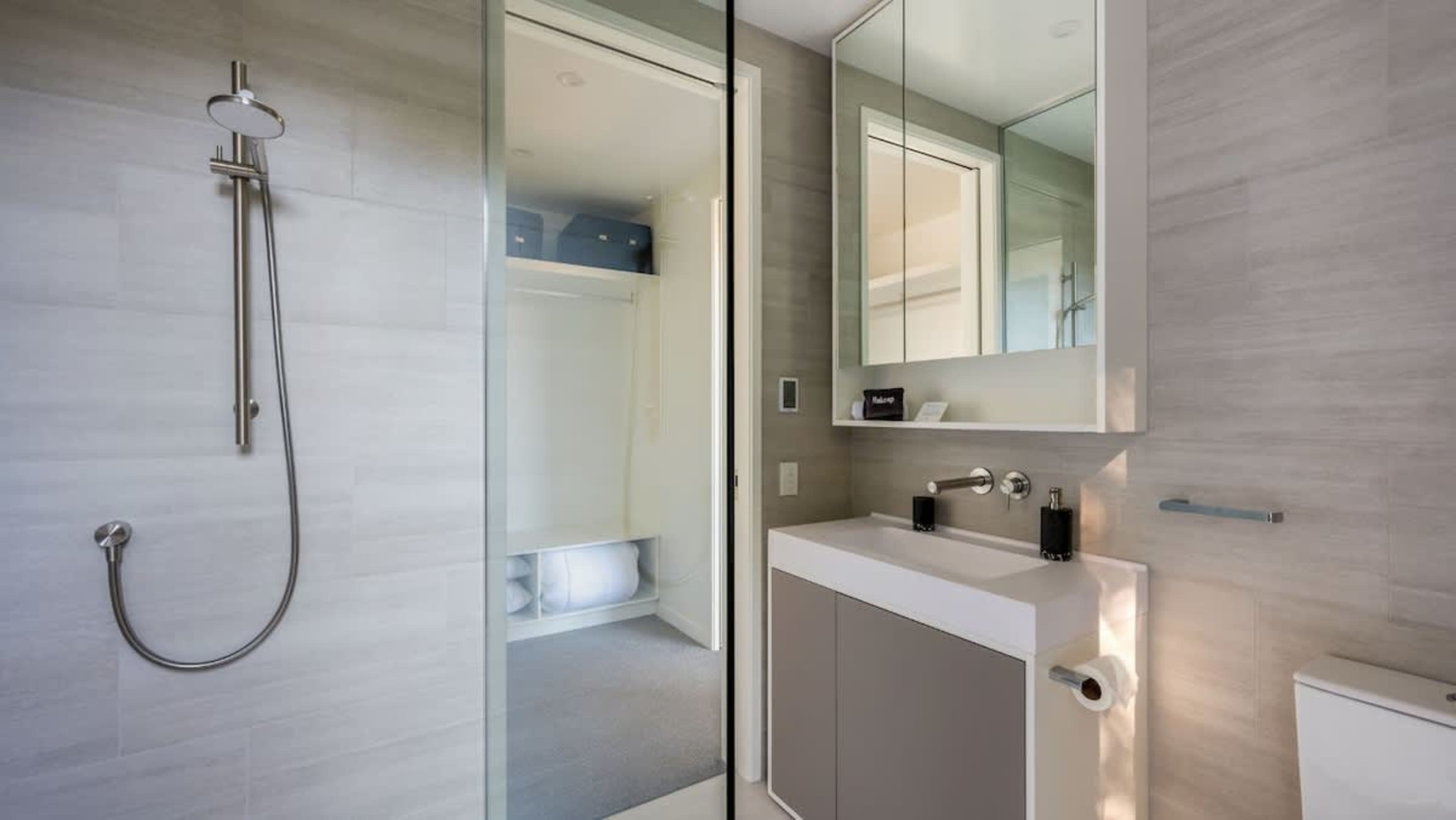 This stylish master ensuite includes heated floors, towel rails, and a spacious alleyway, providing both comfort and convenience in a beautifully designed space.