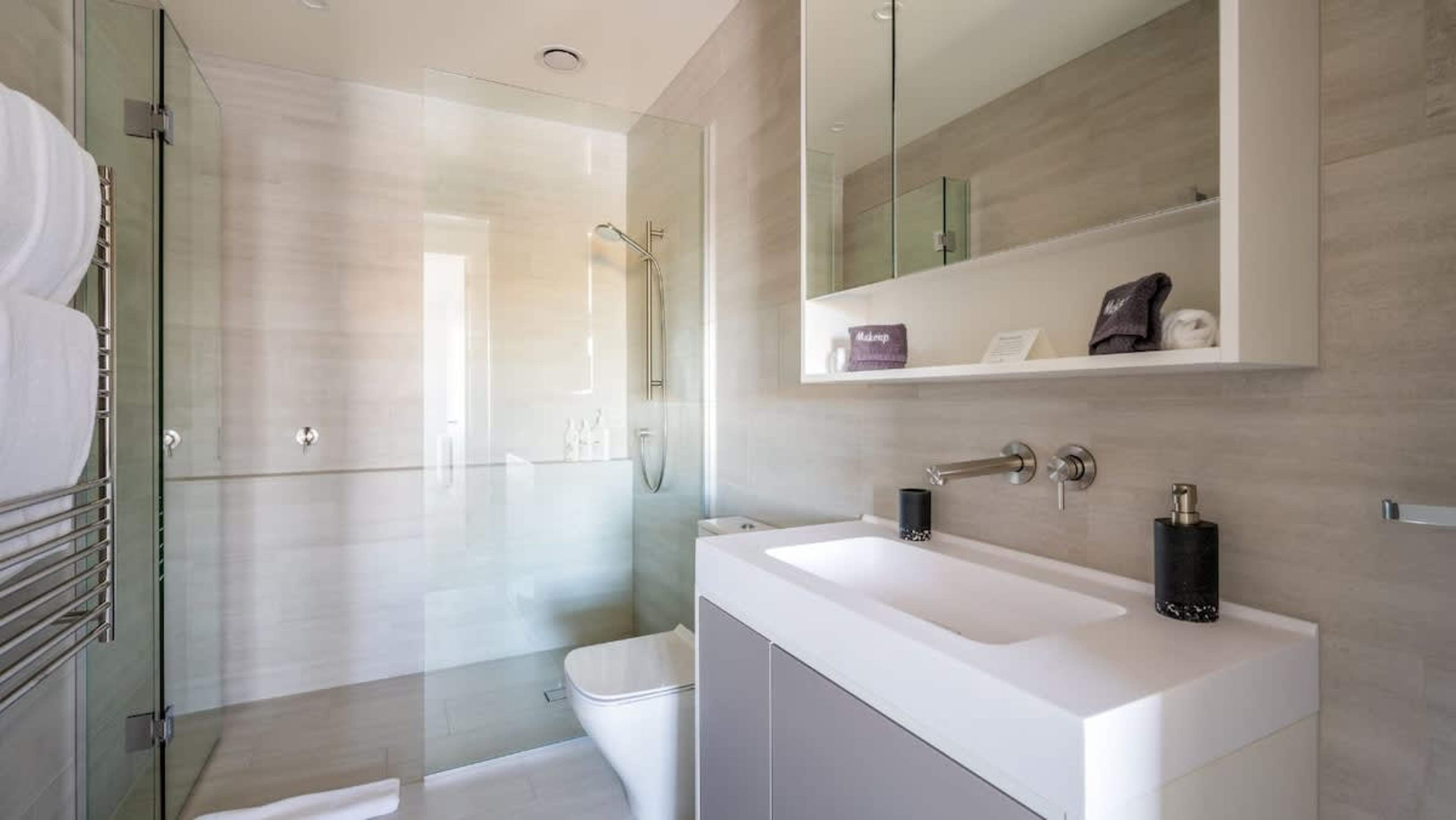The second bathroom is equipped with premium fixtures, including luxurious Ashley & Co toiletries, a spacious shower, and elegant finishes for a spa-like experience.