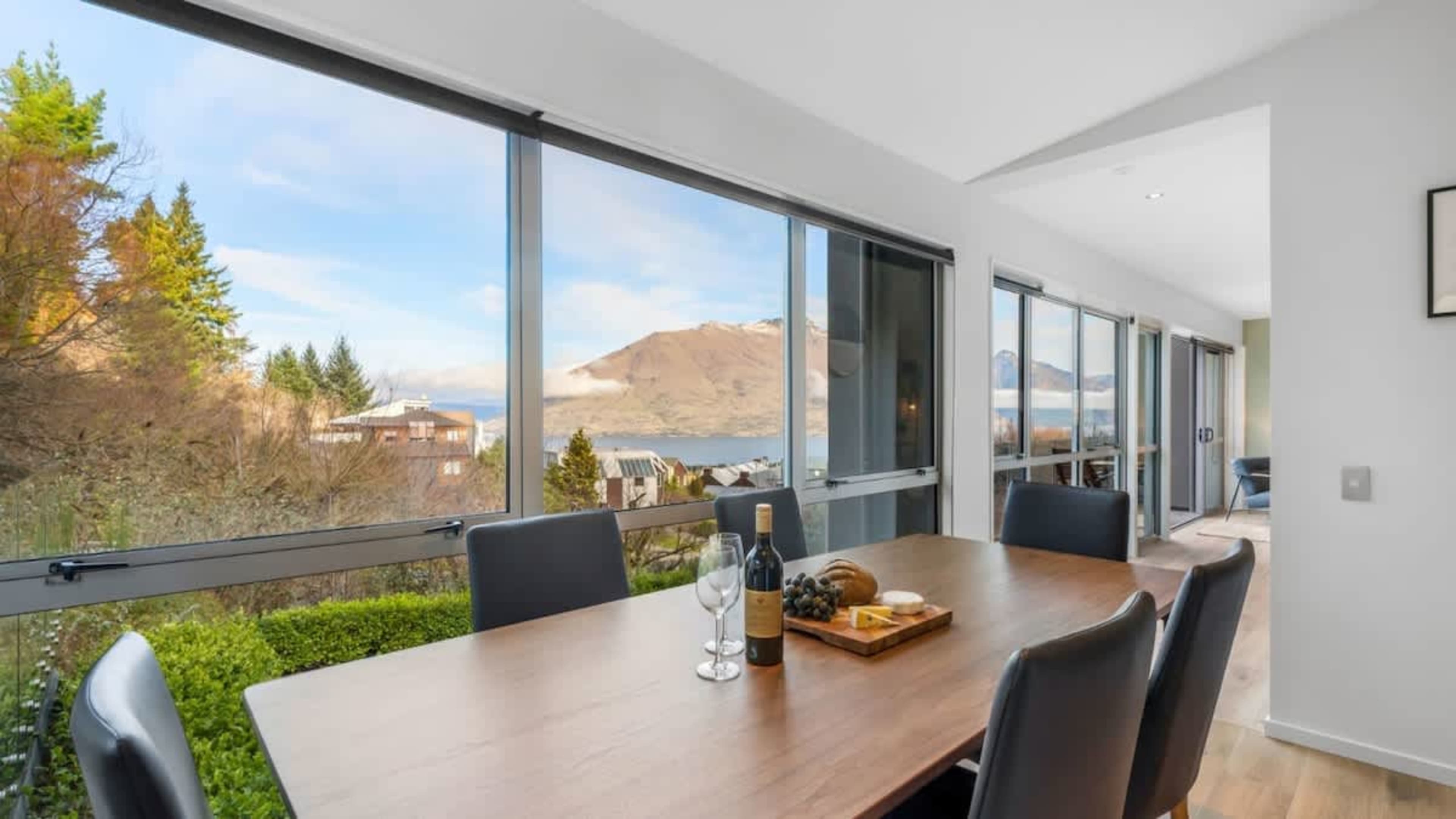 Dining Room with Scenic Views
Gather around the stylish dining table in this bright space, offering expansive lake and mountain views, creating the perfect setting for meals with family and friends.