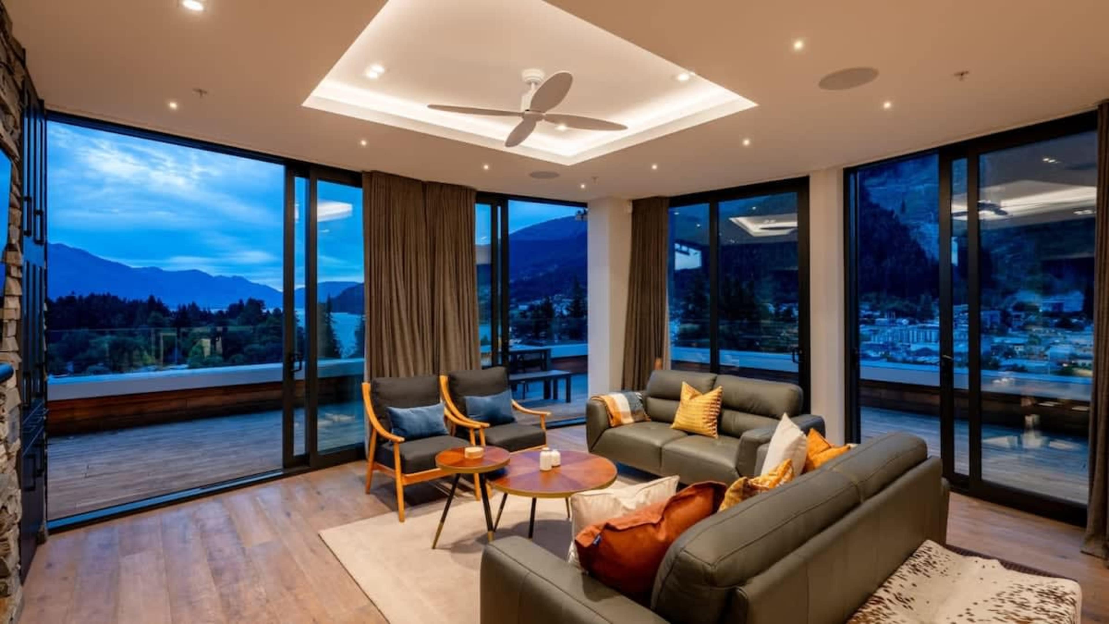 Elegant Living Room with Modern Comforts
Unwind in the stylish living room, complete with a gas fire, AC, and luxurious furnishings, all set against a backdrop of panoramic mountain and lake views.