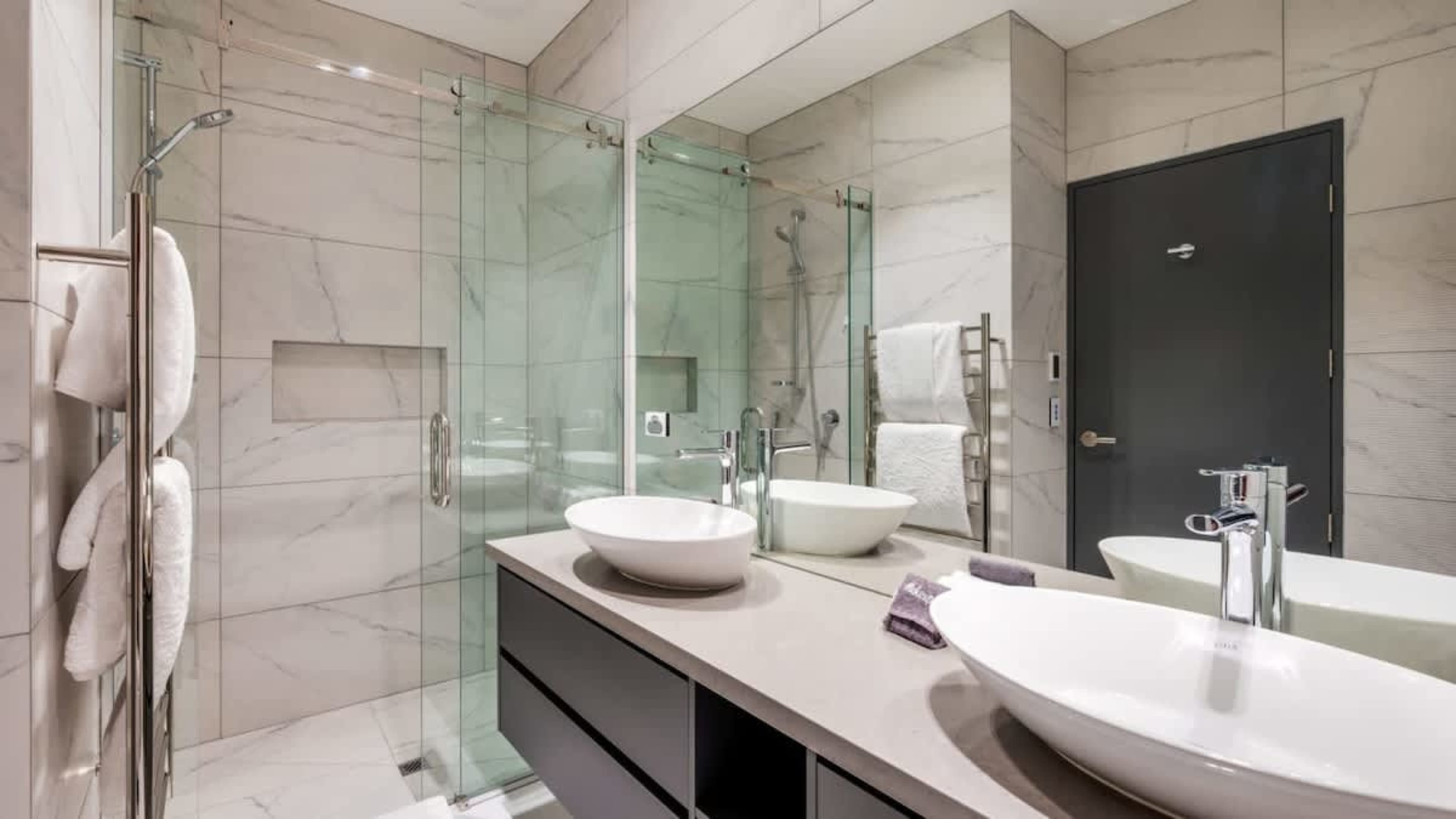 
Second Bathroom with His and Her Sinks, Walk-In Shower, Heated Floors, and Ashley & Co Amenities
Relax in the second bathroom, offering his and her sinks, a walk-in shower, heated floors for extra warmth, and luxurious Ashley & Co toiletries.