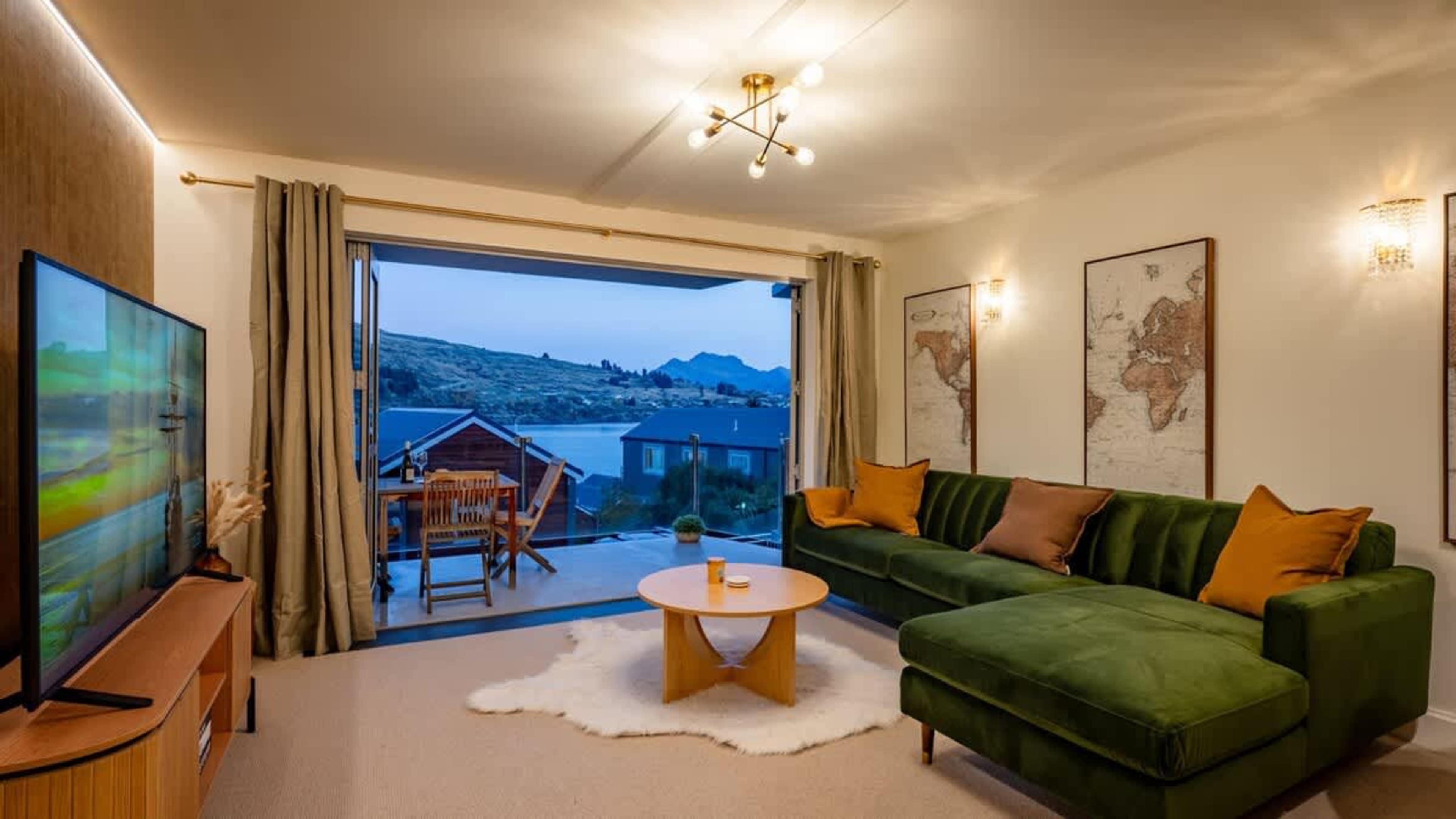Enjoy uninterrupted mountain and lake views from the stylish living area, featuring large windows and plush seating.