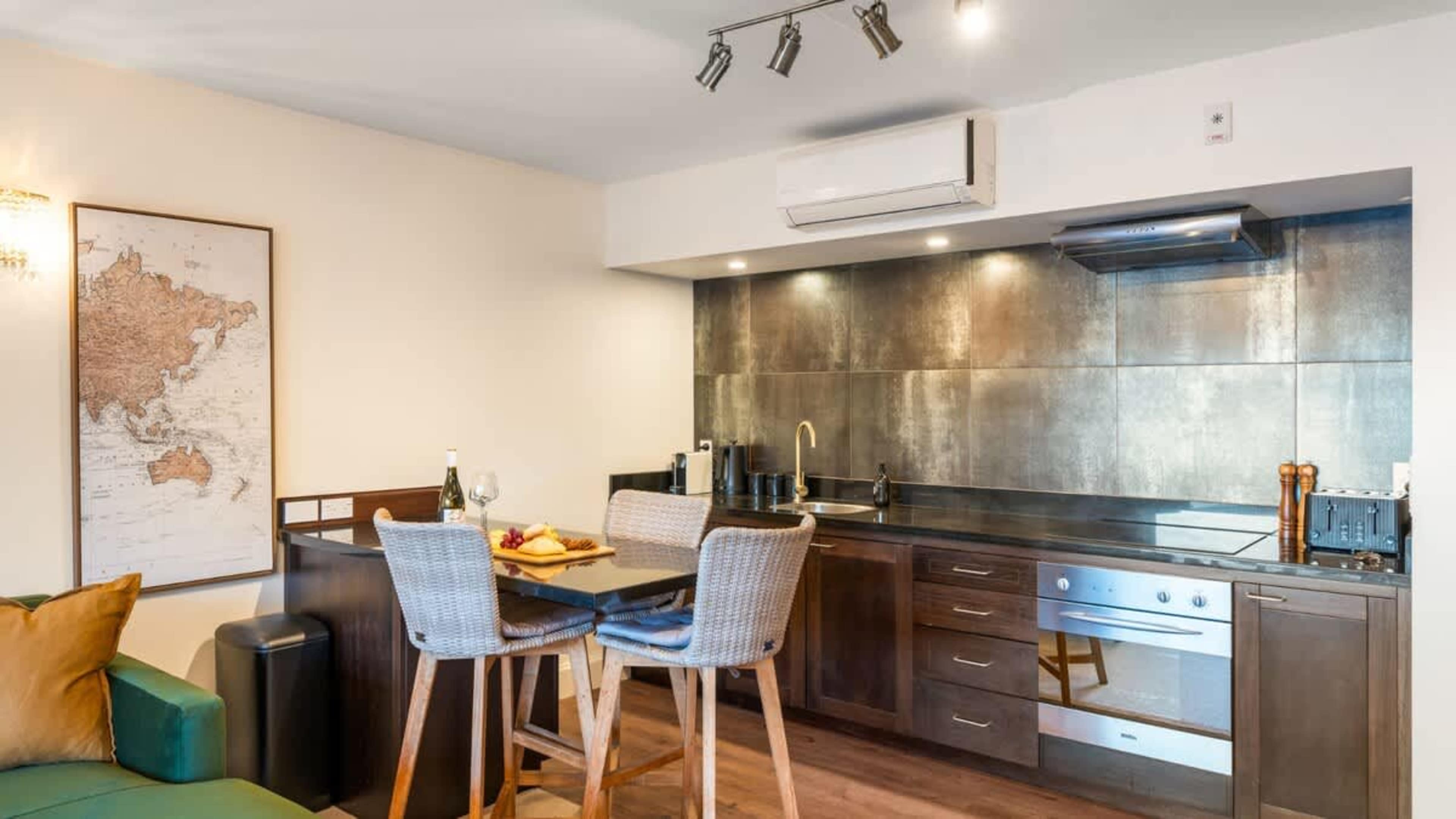 Stylish dining area with a table for four, set against a backdrop of breathtaking lake and mountain views—ideal for enjoying meals or a glass of wine.