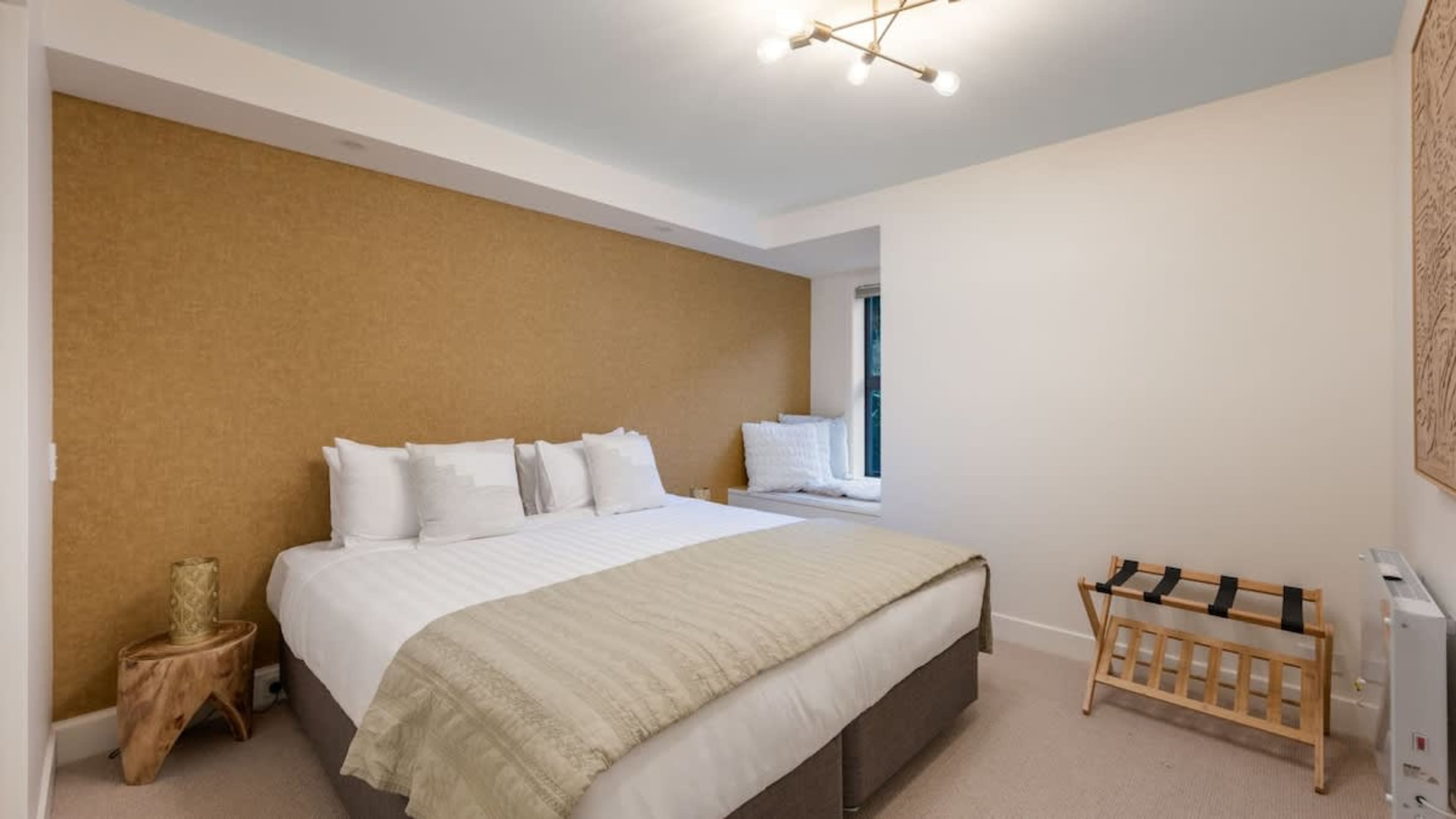 Indulge in comfort in the master bedroom, featuring a plush king bed, stylish decor, and stunning Queenstown vistas.