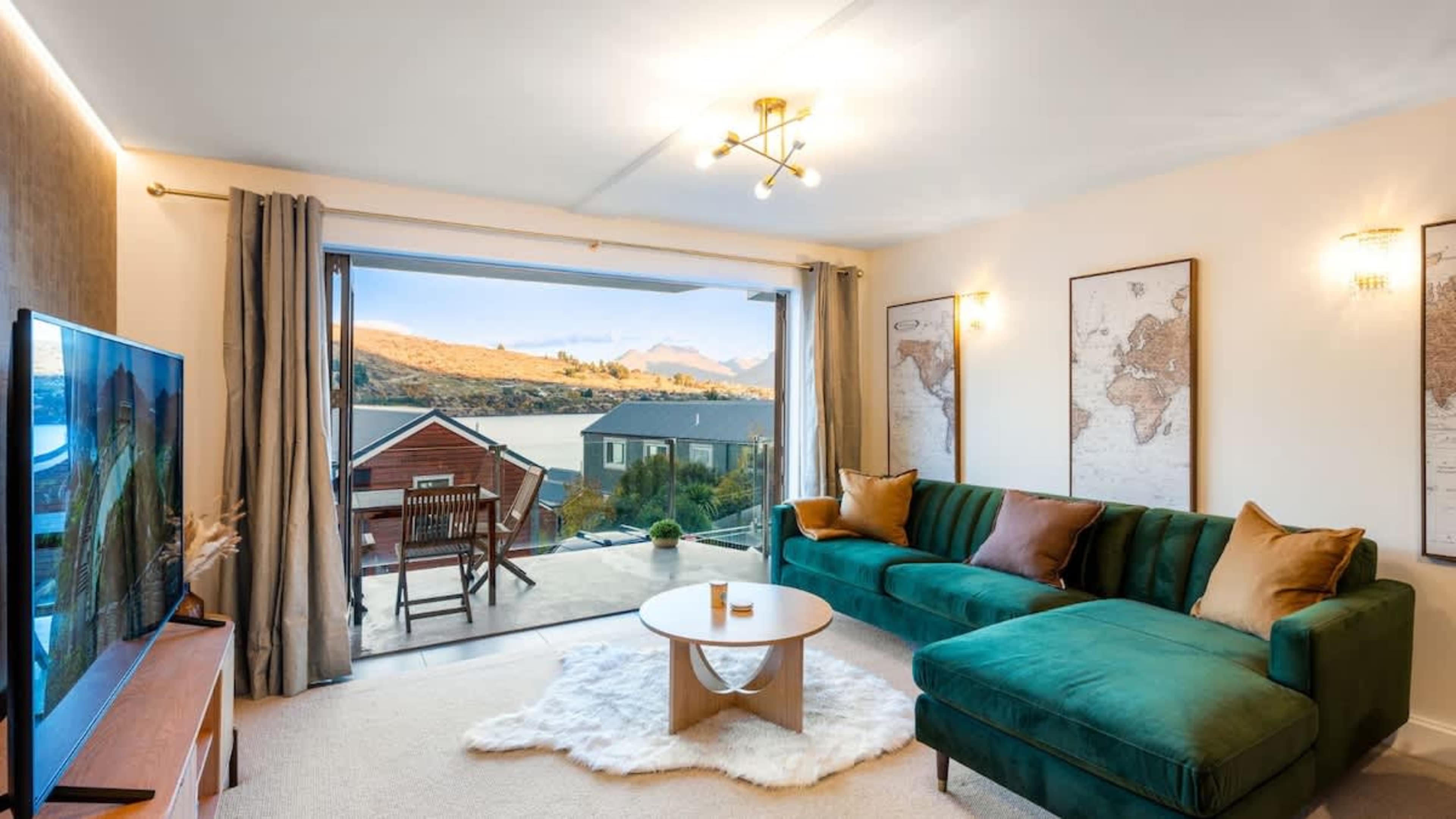 Relax in the cozy living room, complete with a lake-view backdrop, contemporary decor, and ample natural light.