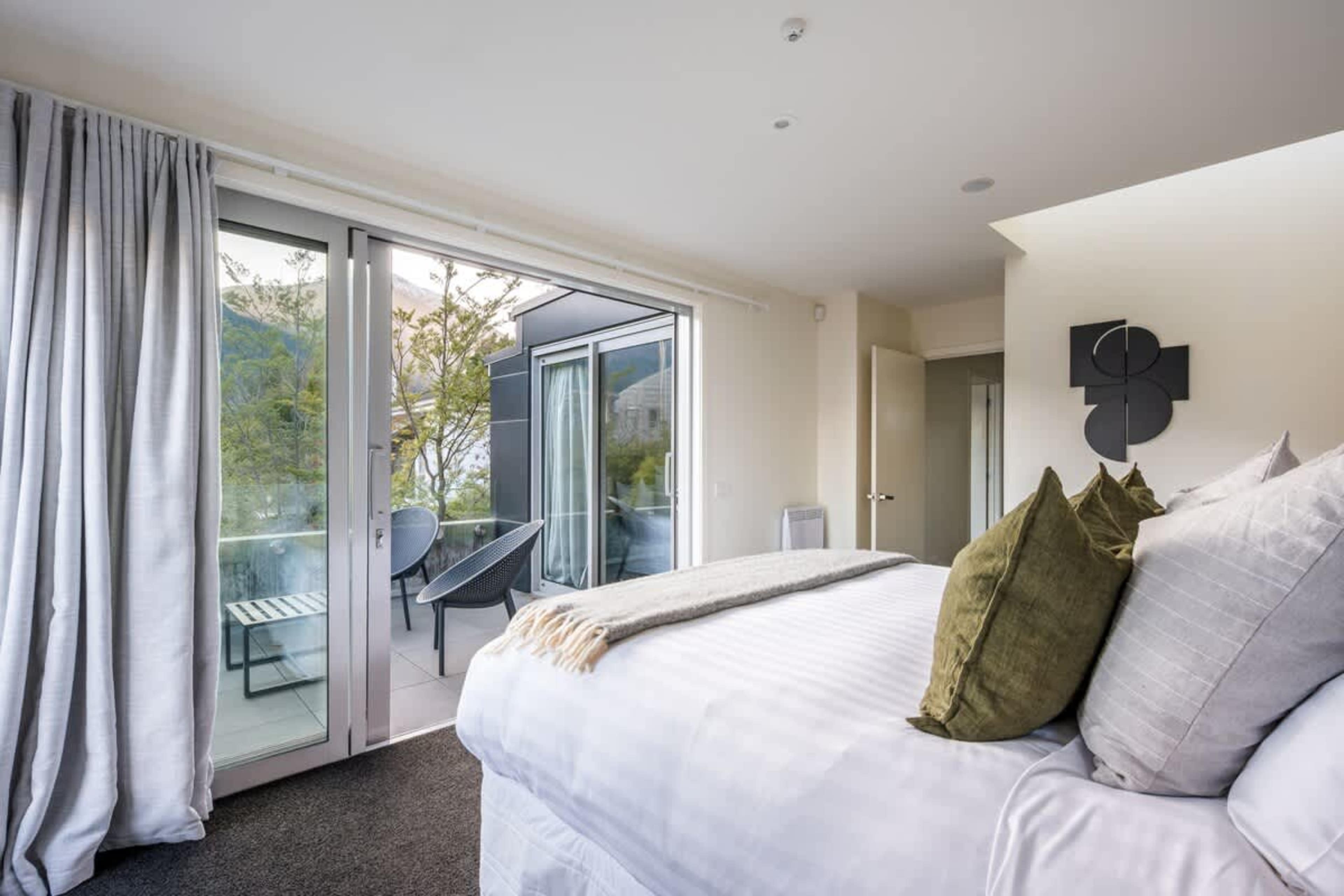 Simply stylish Master Bedroom with Outdoor Access Step out onto this bright and sunny patio with beautiful morning sun for a fresh start to your Queenstown stay.