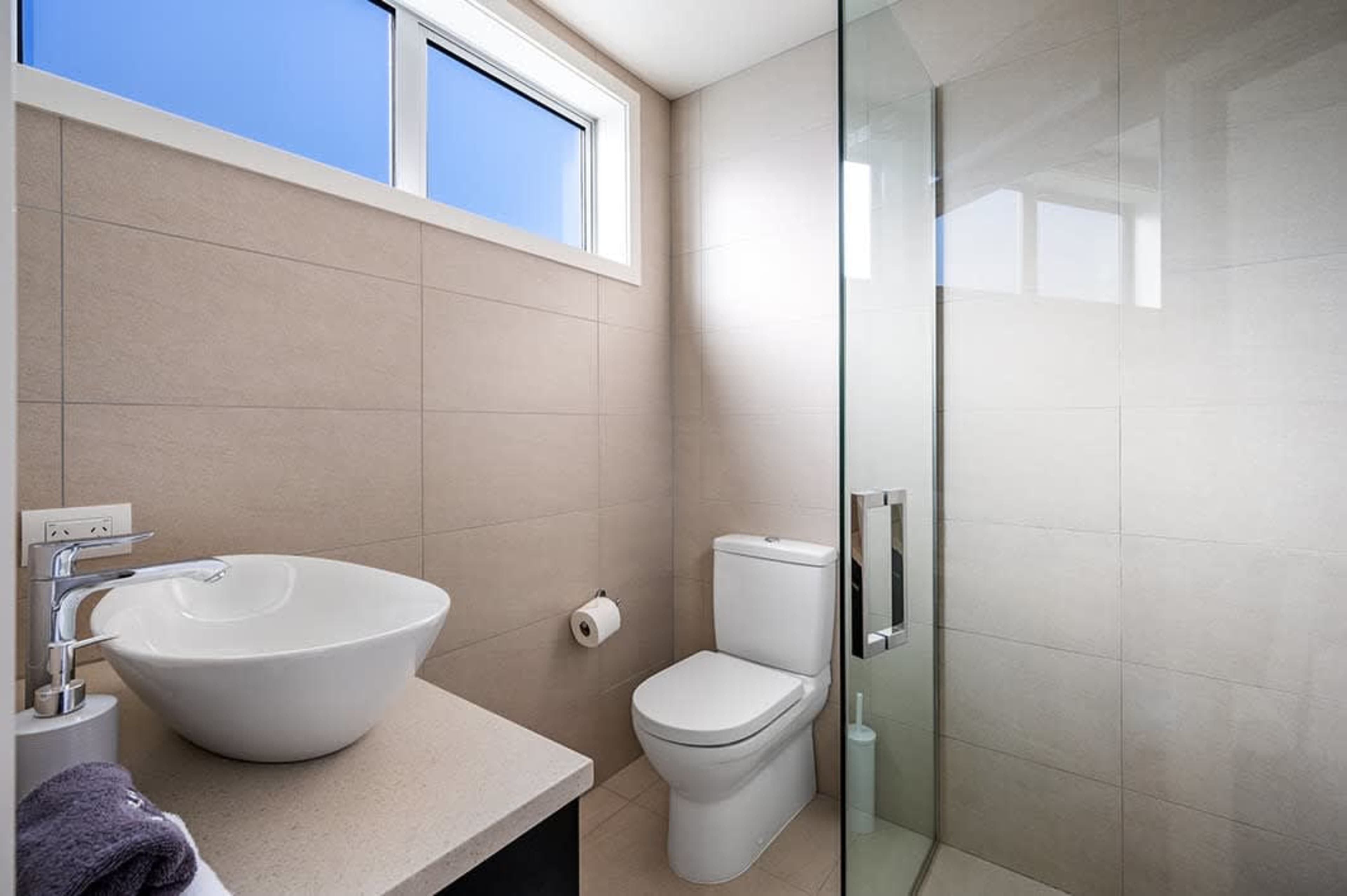 Spacious Third Ensuite with Modern Amenities
This ensuite offers a refreshing walk-in shower and modern amenities. With its stylish design, it complements the third bedroom, providing a private and comfortable space for guests.