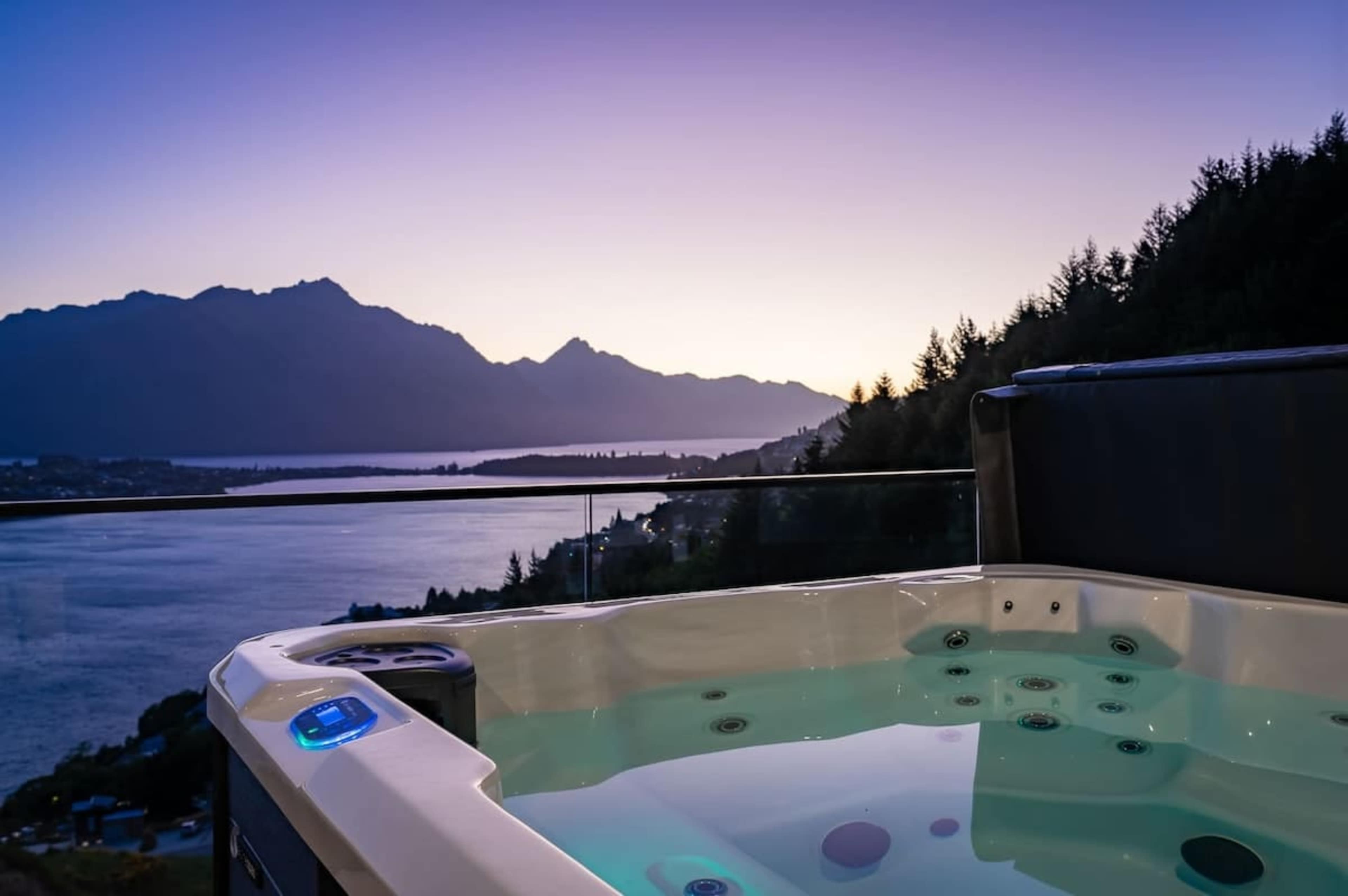 Soak in a private outdoor bathtub with stunning views of Lake Wakatipu and the surrounding mountains in Queenstown.