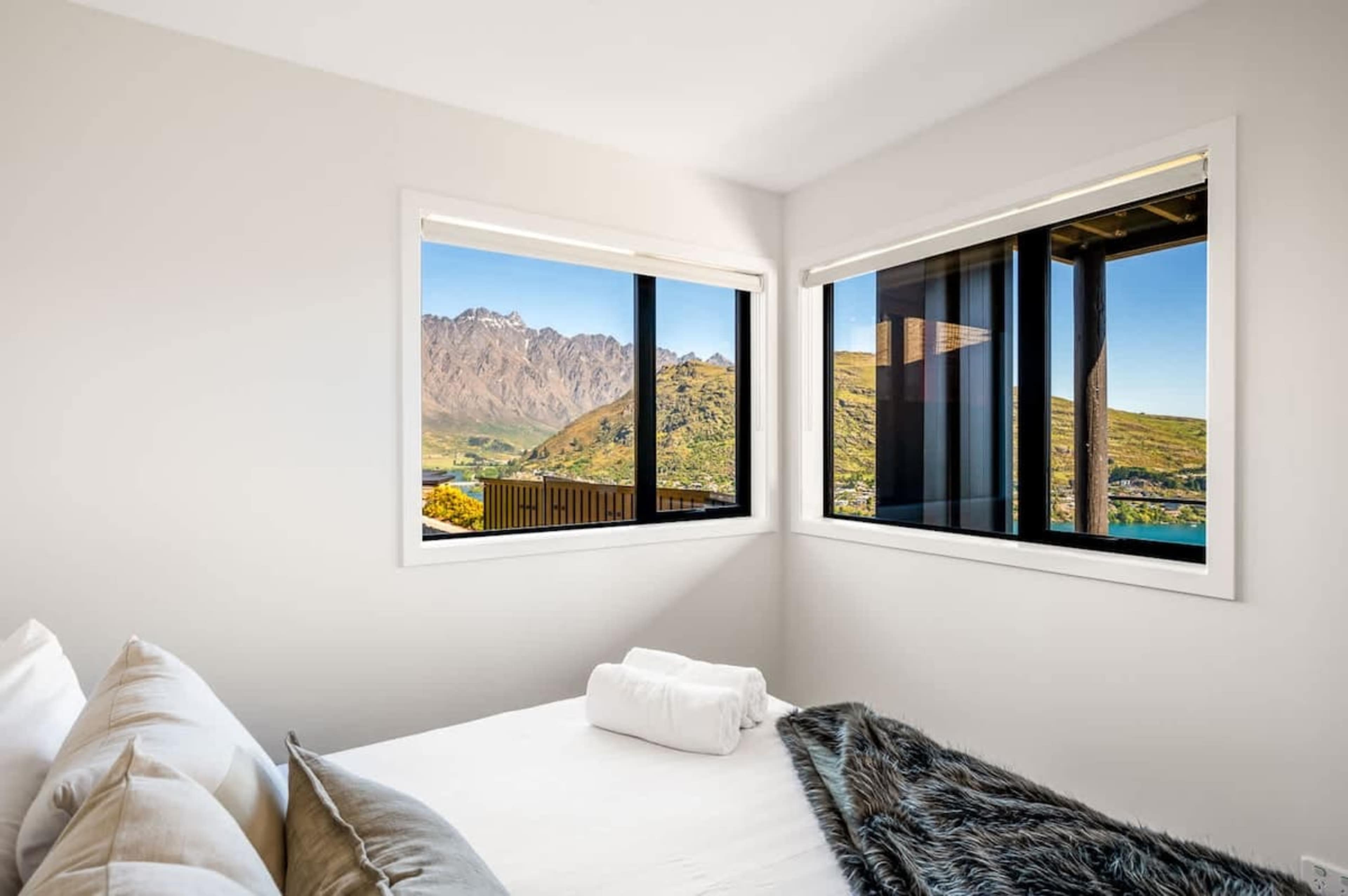 Fourth Bedroom with Mountain Views – This inviting fourth bedroom offers expansive windows that showcase the stunning Queenstown mountains, providing a peaceful and scenic retreat for guests.