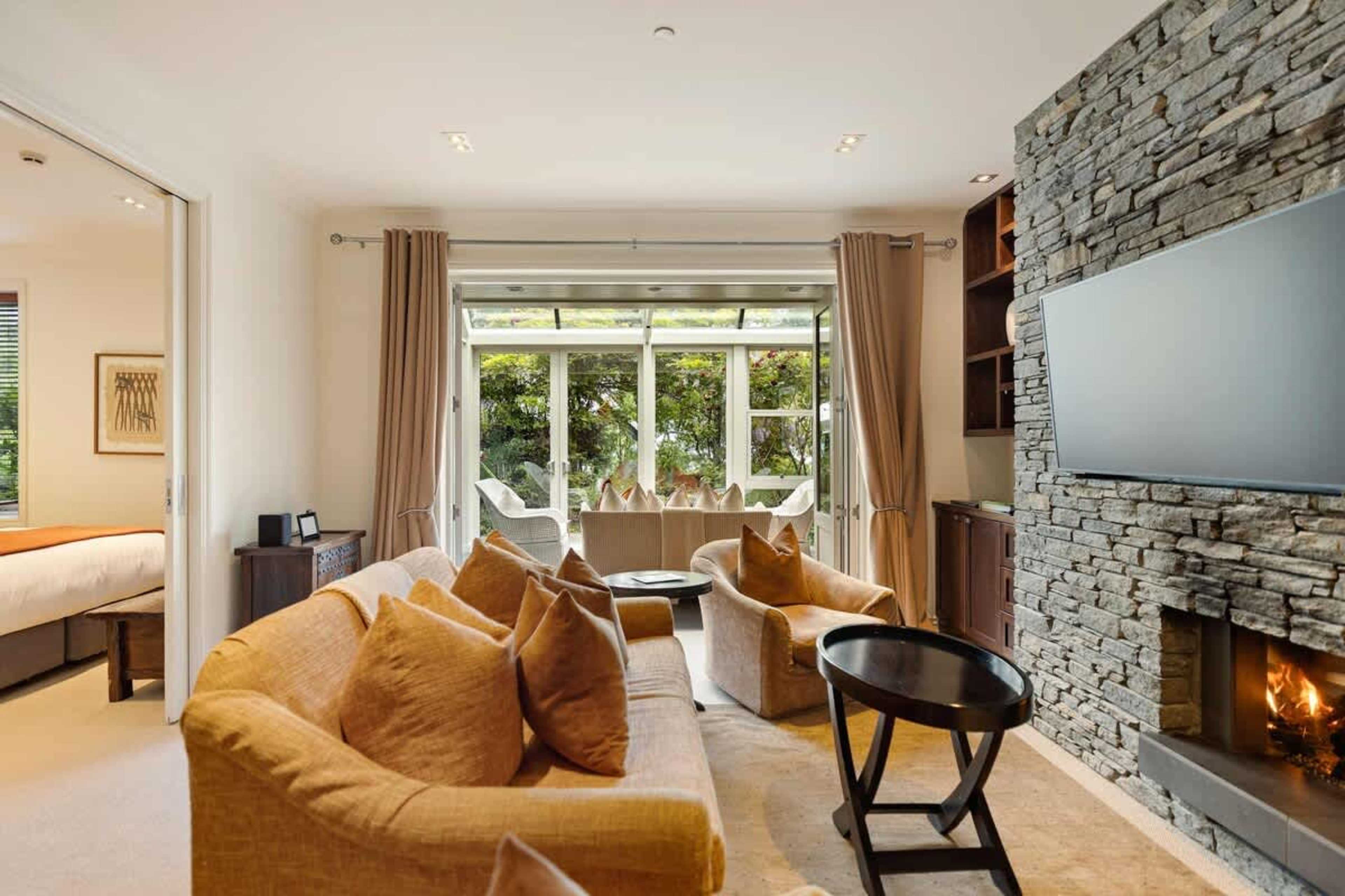 Cozy Up by the Fire or Bask in the Sun – Whether you're unwinding by the gas fireplace or enjoying the warmth of the conservatory, this living area is the perfect Queenstown retreat.