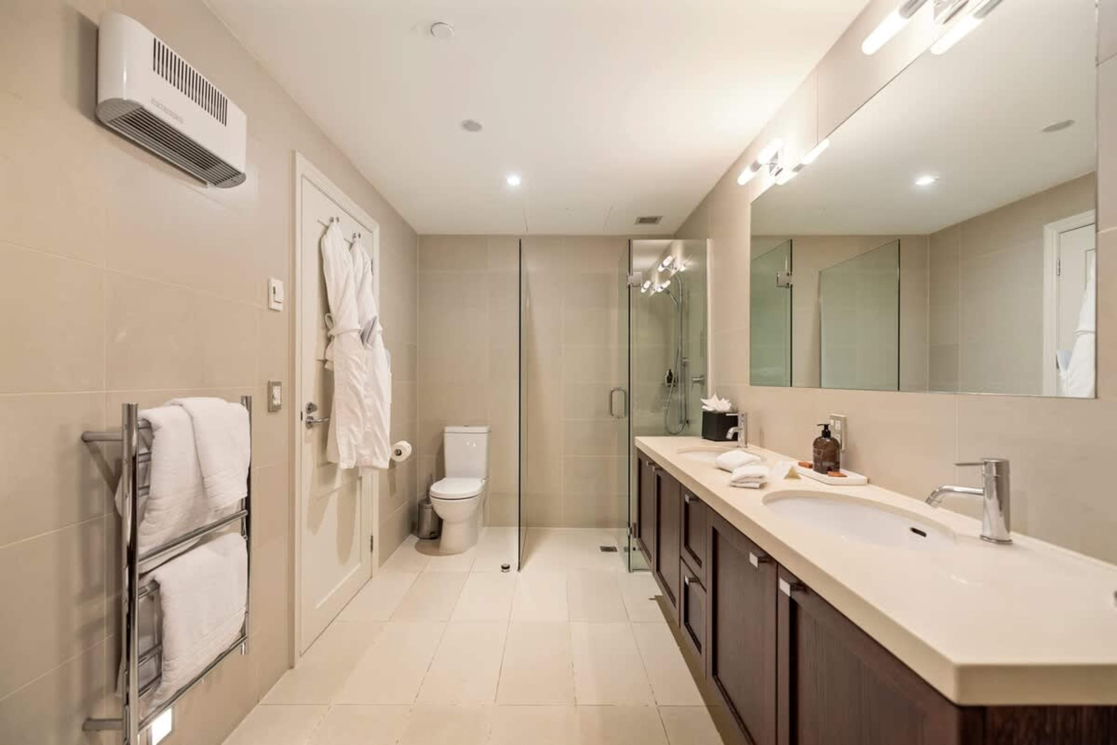Elegant Ensuite with Premium Amenities – This modern ensuite bathroom includes a rain shower, luxury bathrobes, slippers, and hotel-grade towels, creating a serene and indulgent experience.