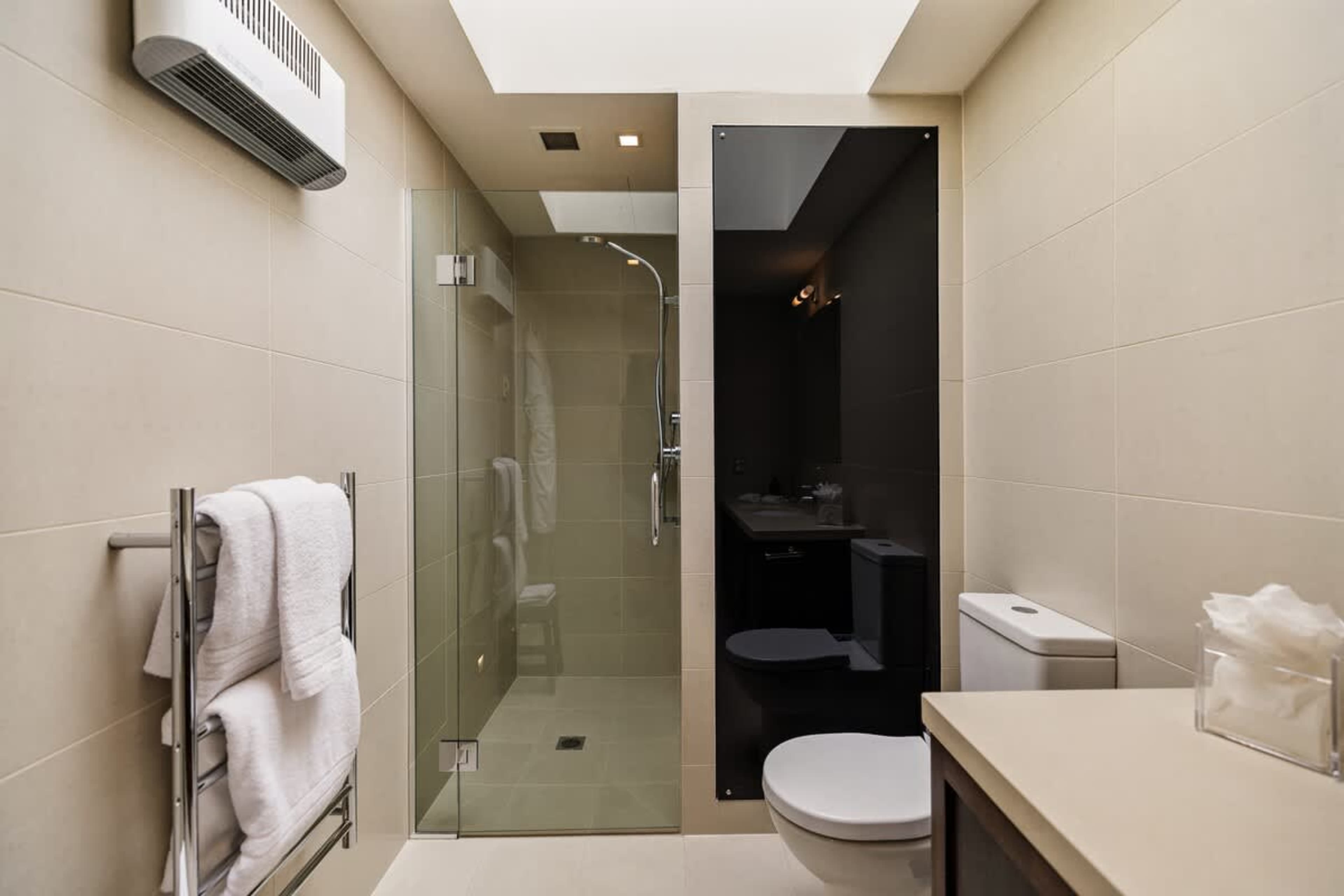 Luxury Ensuite Bathroom – Pamper yourself in this sleek ensuite, featuring a rain shower, premium toiletries, bathrobes, and slippers, for a true spa-like experience during your stay.