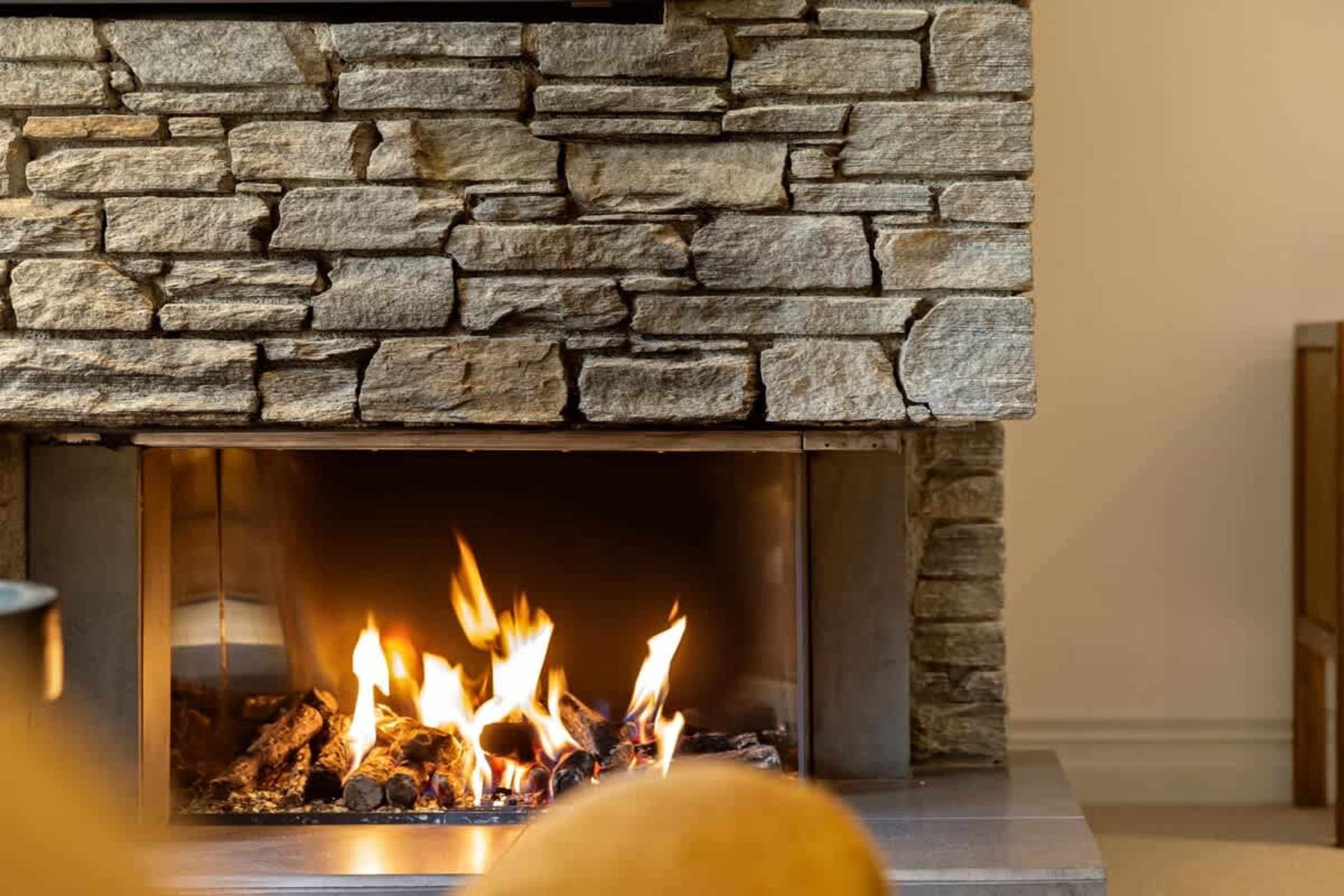 Bright Living Room with Scenic Views – Enjoy a cozy evening in front of the gas fireplace, with air-conditioning for year-round comfort. The living room opens to a private patio, giving you direct access to views of Lake Wakatipu.