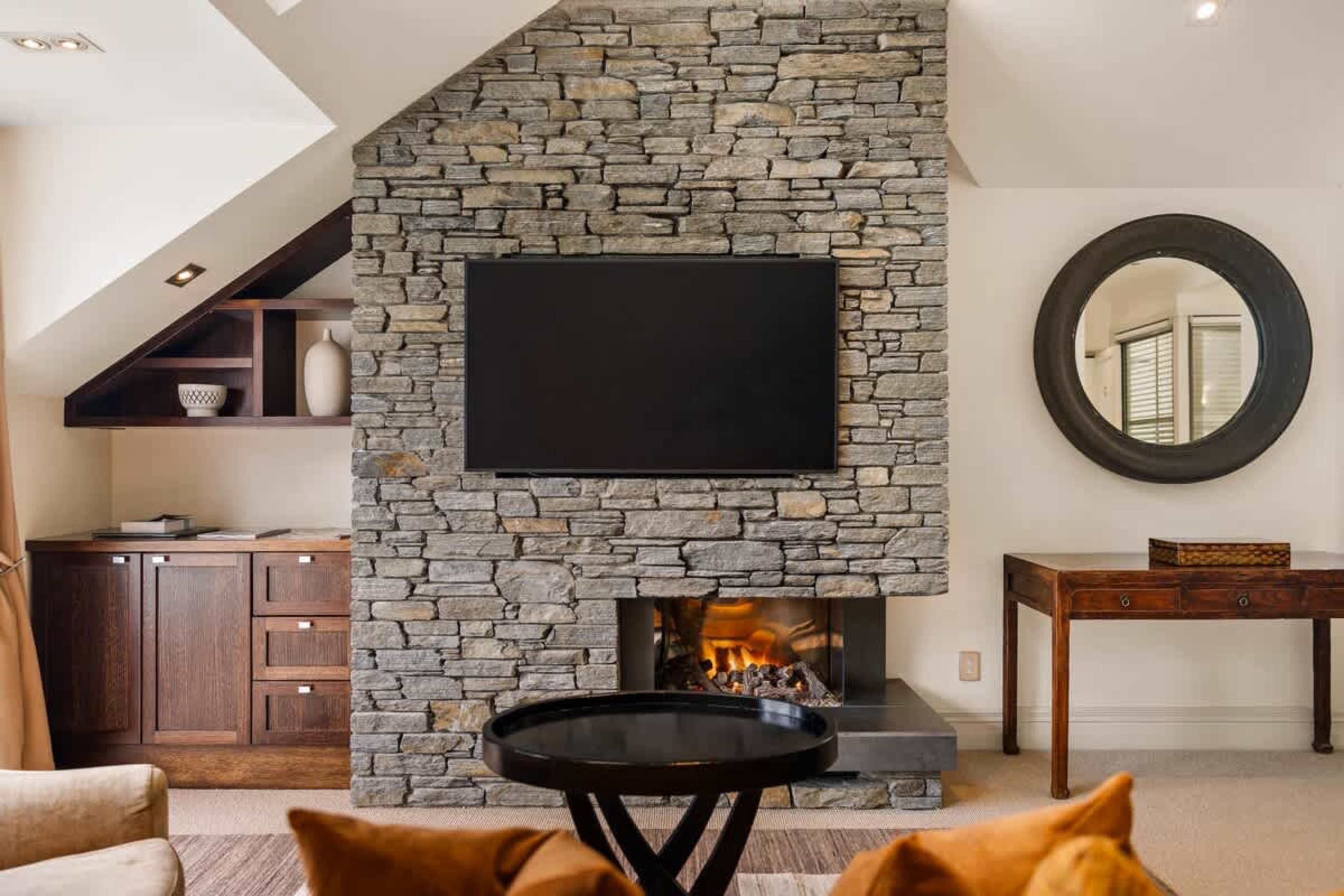 Cozy Up with Stunning Views – Enjoy a quiet evening by the fireplace or take in breathtaking views of the lake and mountains from this spacious, stylish living room in the heart of Queenstown.