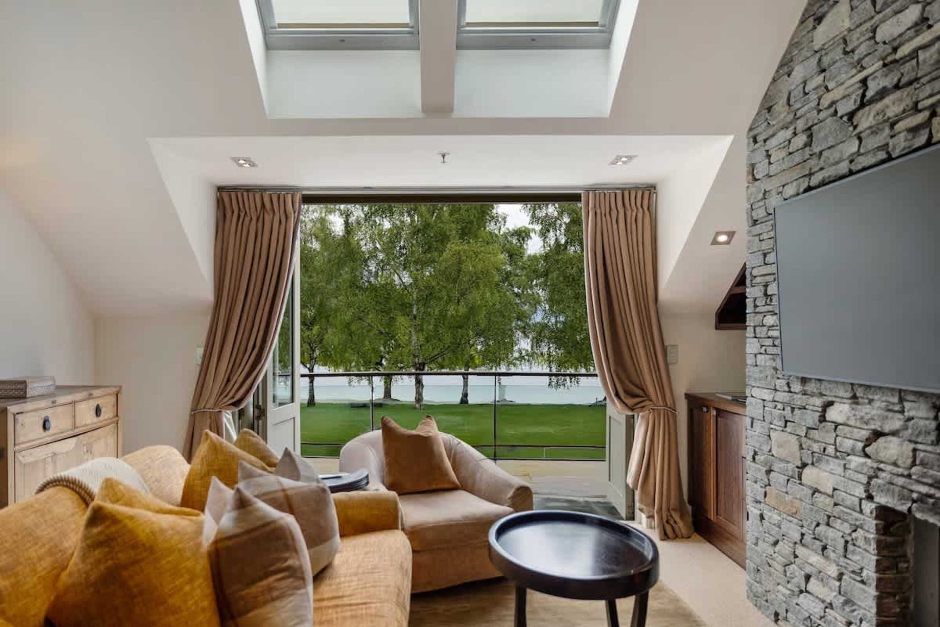 Stylish & Cozy Living Space – Relax in the elegant lounge, featuring plush seating, a gas fireplace, and air-conditioning, all leading to a private balcony with stunning views.