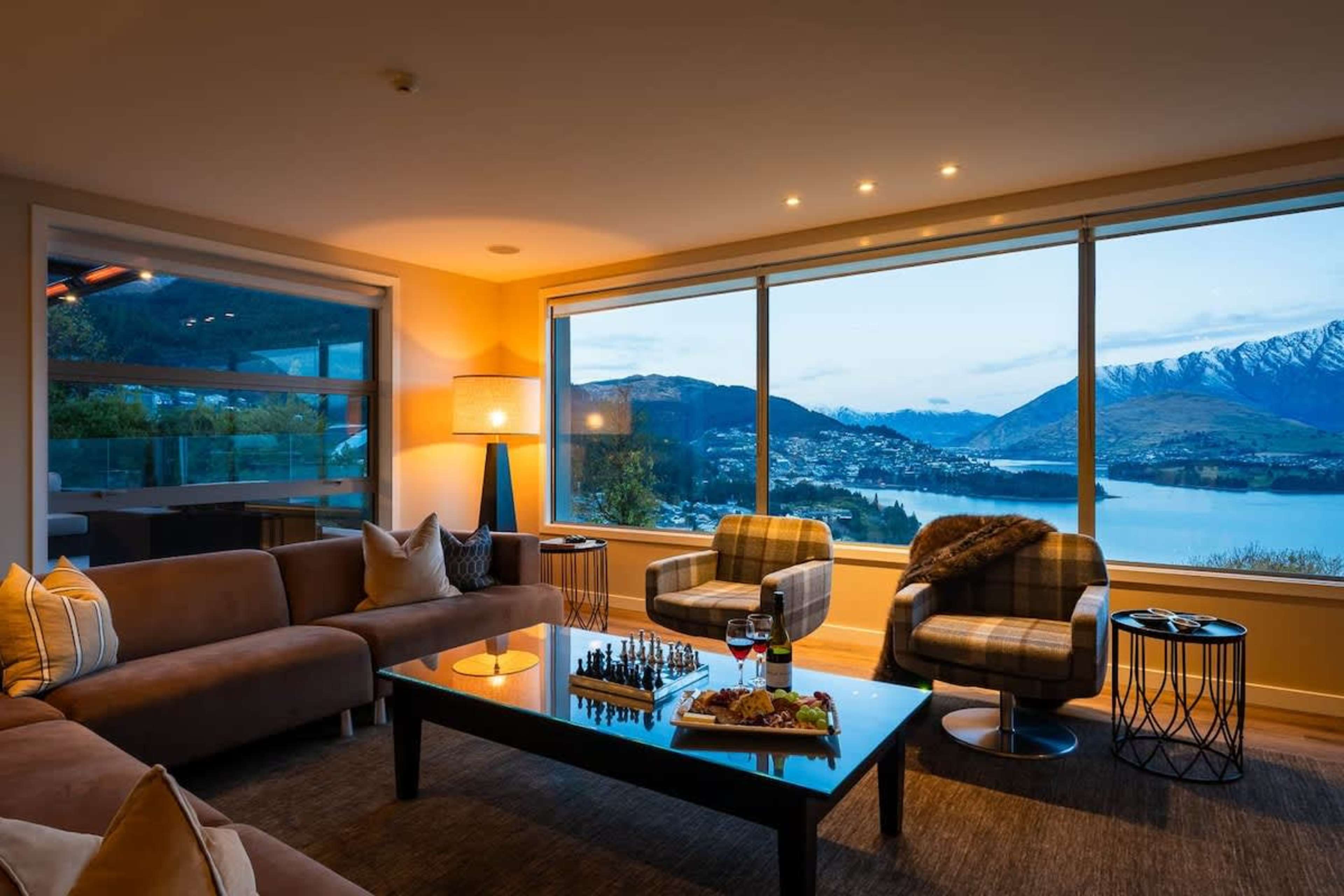 The spacious open-plan living area features modern décor and comfortable seating. It’s an inviting space for family and friends to gather in Queenstown’s luxury.