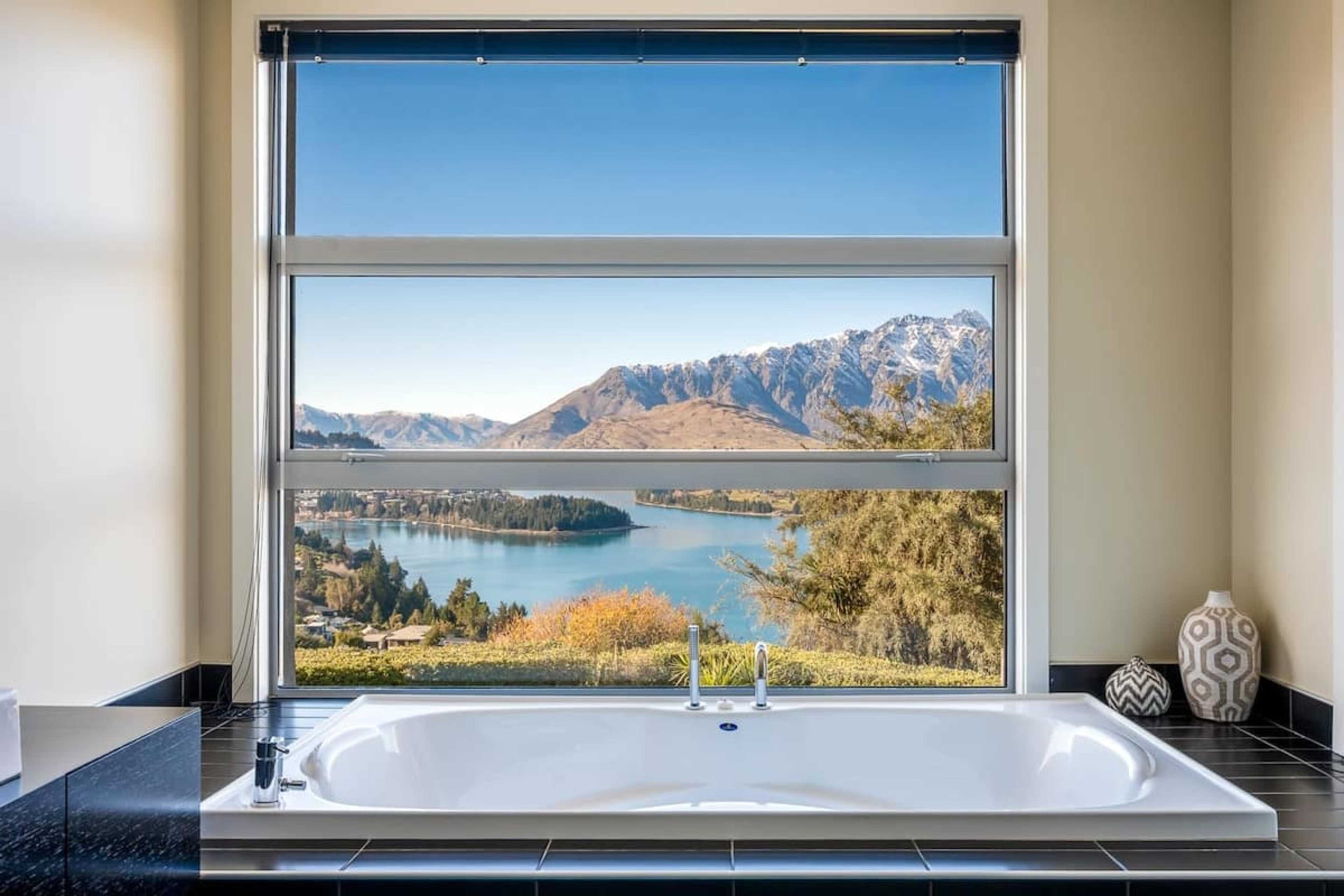 The master ensuite boasts a sleek, modern design with large windows framing stunning lake and mountain views. Enjoy a soak in the bath while taking in Queenstown’s breathtaking scenery.