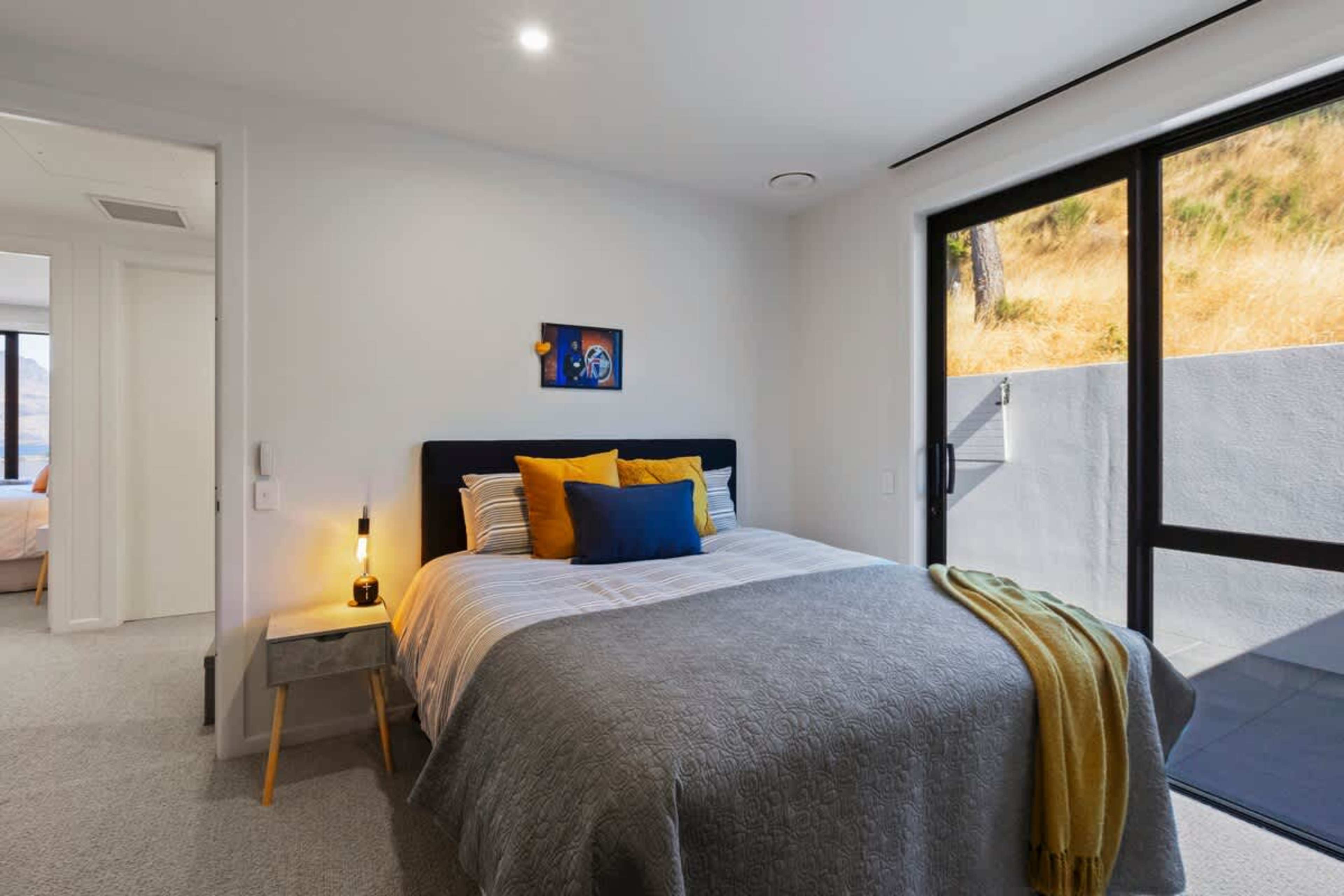 The third bedroom blends modern comfort with mountain outlooks. It’s a peaceful retreat after a day of Queenstown adventures.
