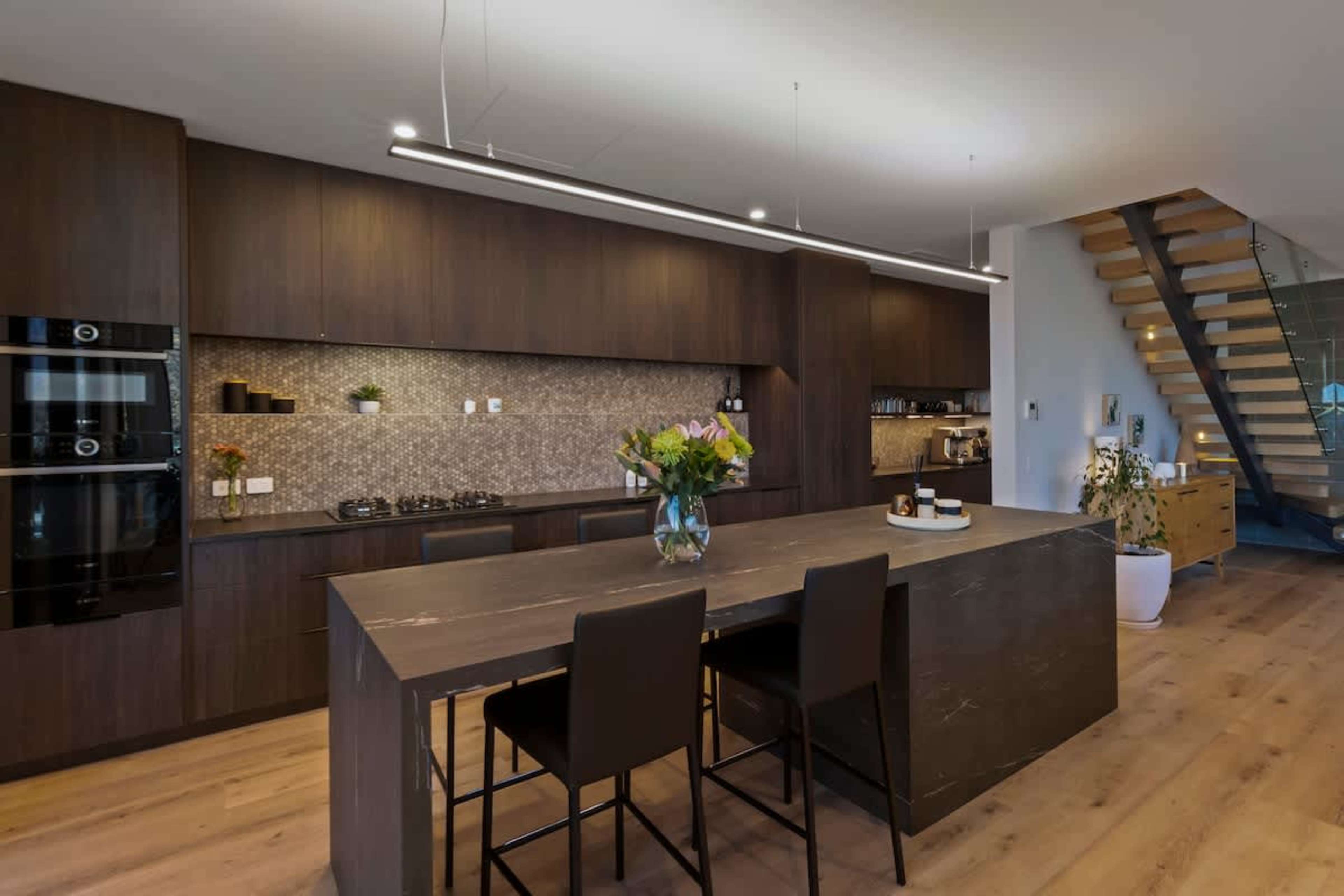 Start your mornings with a fresh Nespresso in the gourmet kitchen, sunlight streaming over the island bench. Cook, gather, and share meals while lake views provide the perfect backdrop.