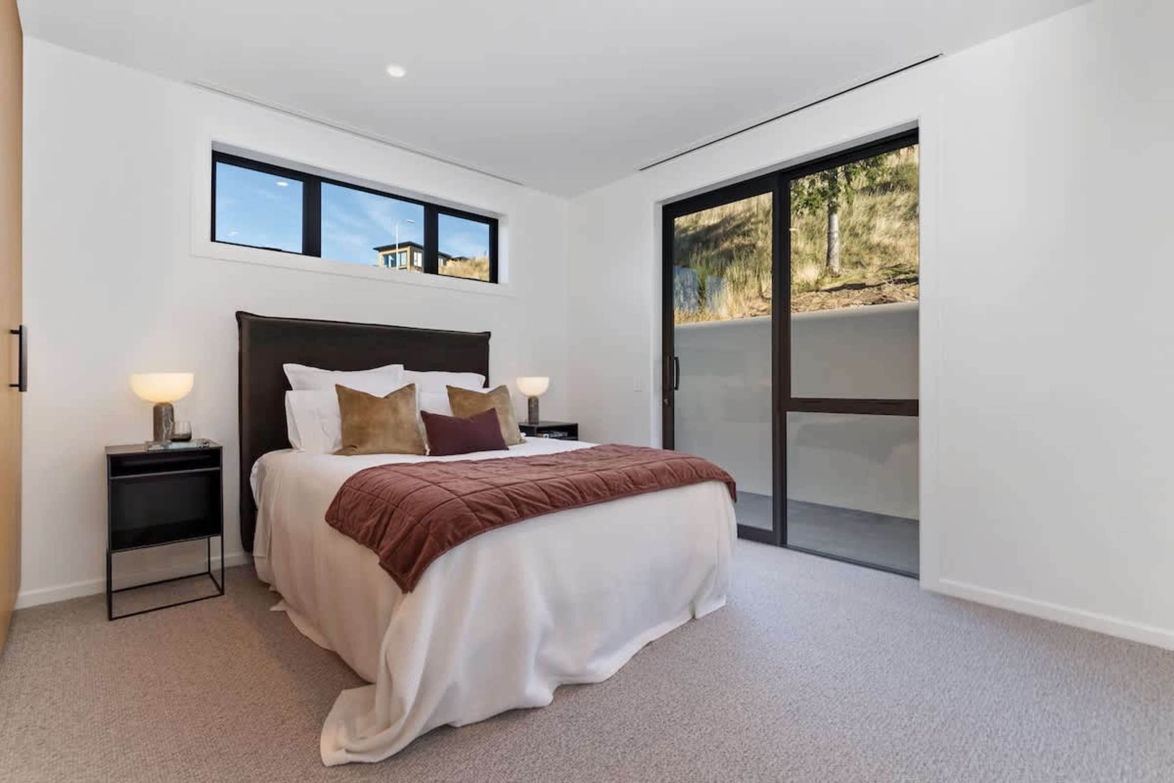 Natural light fills the fourth bedroom, warm and inviting. Thoughtful design makes it perfect for friends or family.